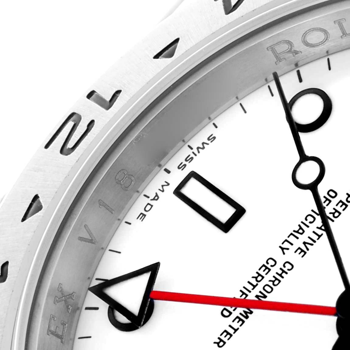 The image shows a close-up of the bezel and dial of a Rolex Explorer 16570 Men's Stainless Steel White Dial watch, highlighting the bezel numbers and watch hands.