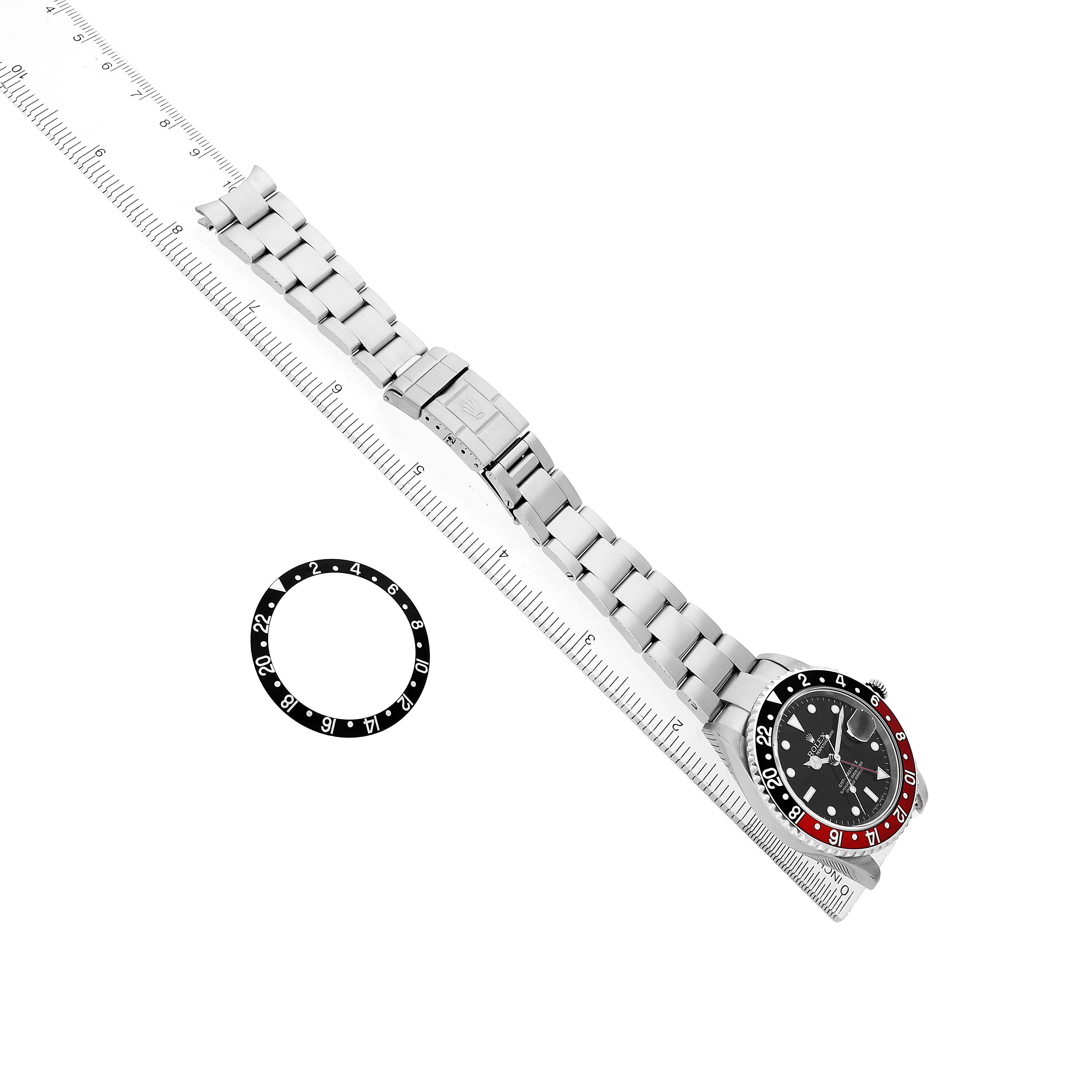 The image shows a top-down view of a Rolex GMT-Master 16710 Men's Stainless Steel Black Dial watch and its bezel separately, with the watch on a ruler.