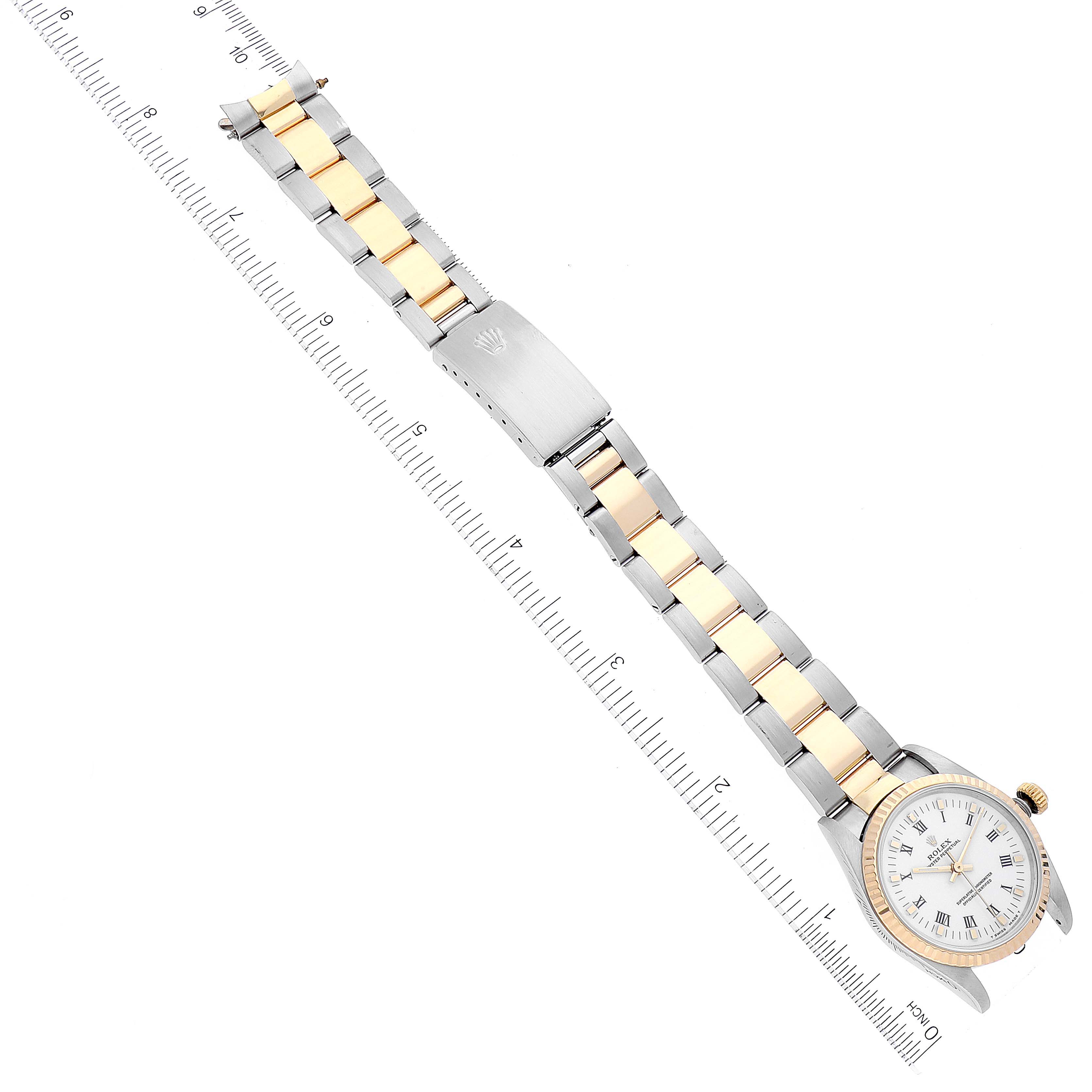 The image shows a Mid-Size Rolex watch with a full view of its bracelet, dial, and clasp at a tilted angle alongside a ruler.