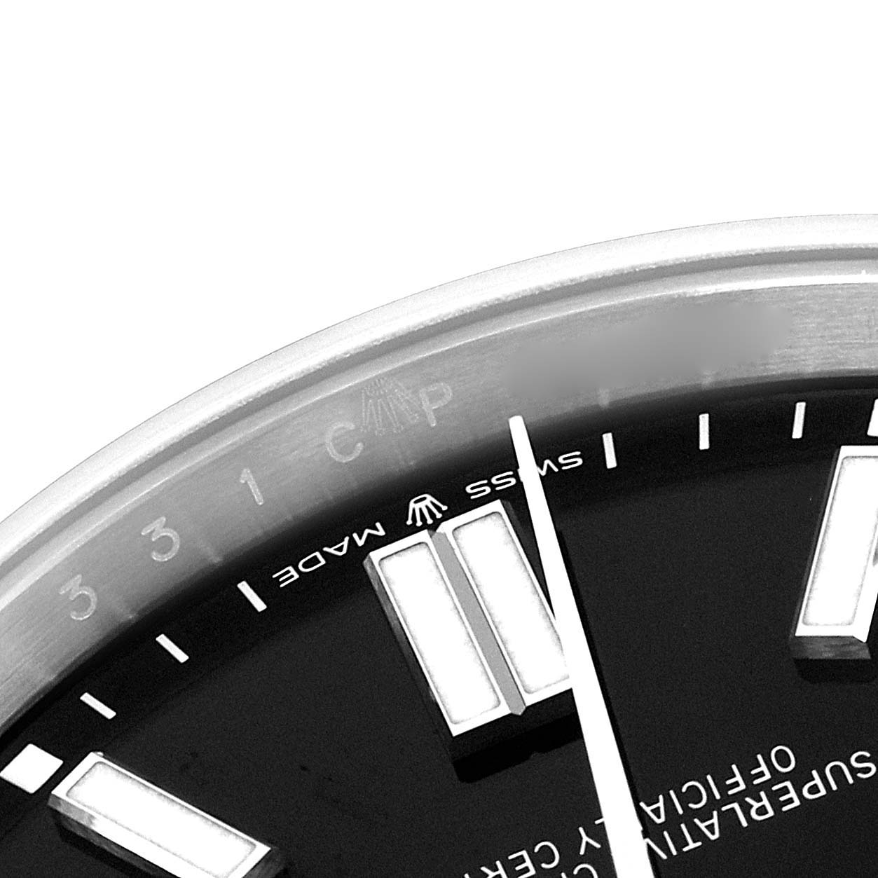 The image shows a close-up of the dial and bezel of a Rolex Oyster Perpetual 124300 Men's Stainless Steel Black Dial watch, highlighting the indices and part of the text.