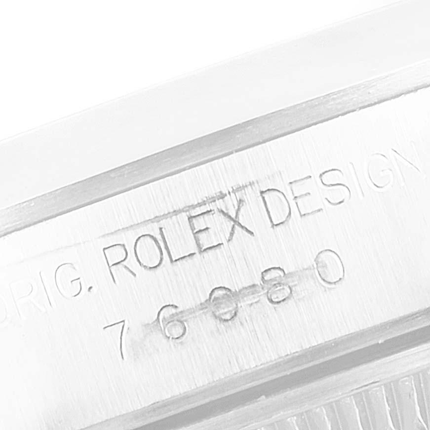 This is a close-up of the case side engraving on a Rolex Oyster Perpetual 76080 Women's Stainless Steel Pink Dial 76080 Women's Stainless Steel Pink Dial watch showing the model number and ROLEX DESIGN inscription.