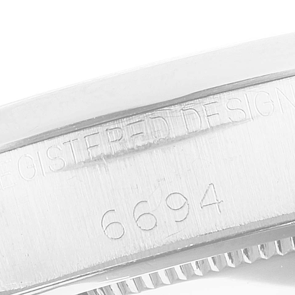 The image shows a close-up of the case side of the Rolex Vintage Collection 6694 Men
s Stainless Steel Silver Dial 6694 Men
s Stainless Steel Silver Dial model, displaying its engraved serial number "6694".