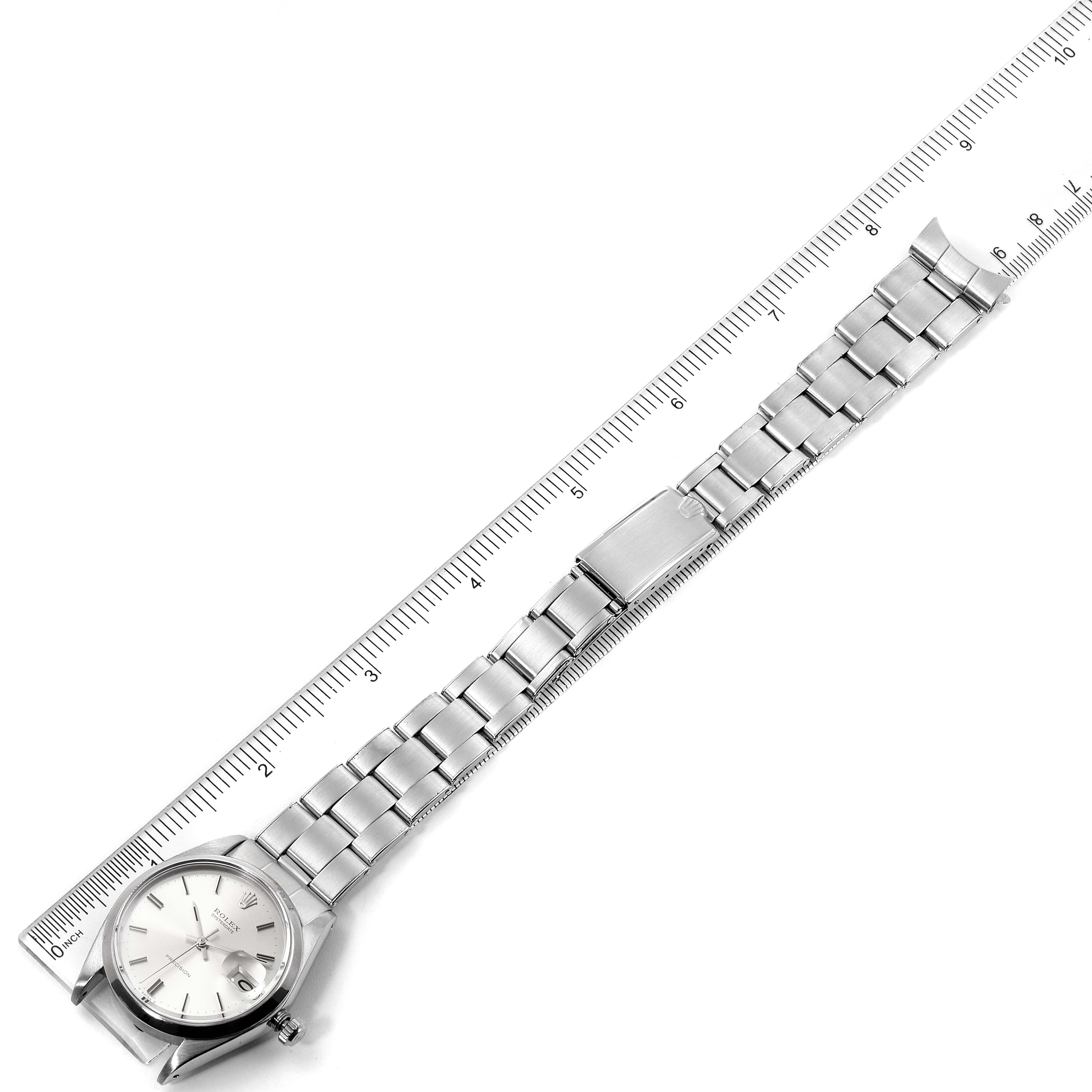 The Vintage Collection Rolex watch is shown from a slightly elevated angle, displaying its face, clasp, and full metal bracelet against a ruler.