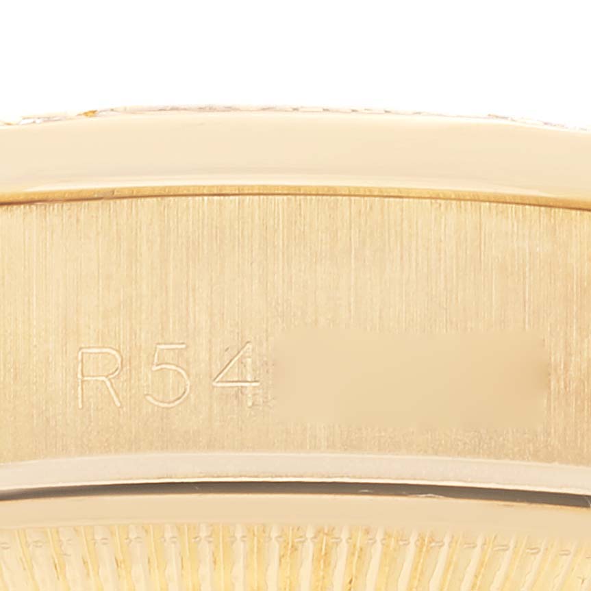 The image shows a close-up of the side of a Rolex President 69158 Women's Yellow Gold Champagne Dial 69158 Women's Yellow Gold Champagne Dial watch, focusing on the engraved serial number.