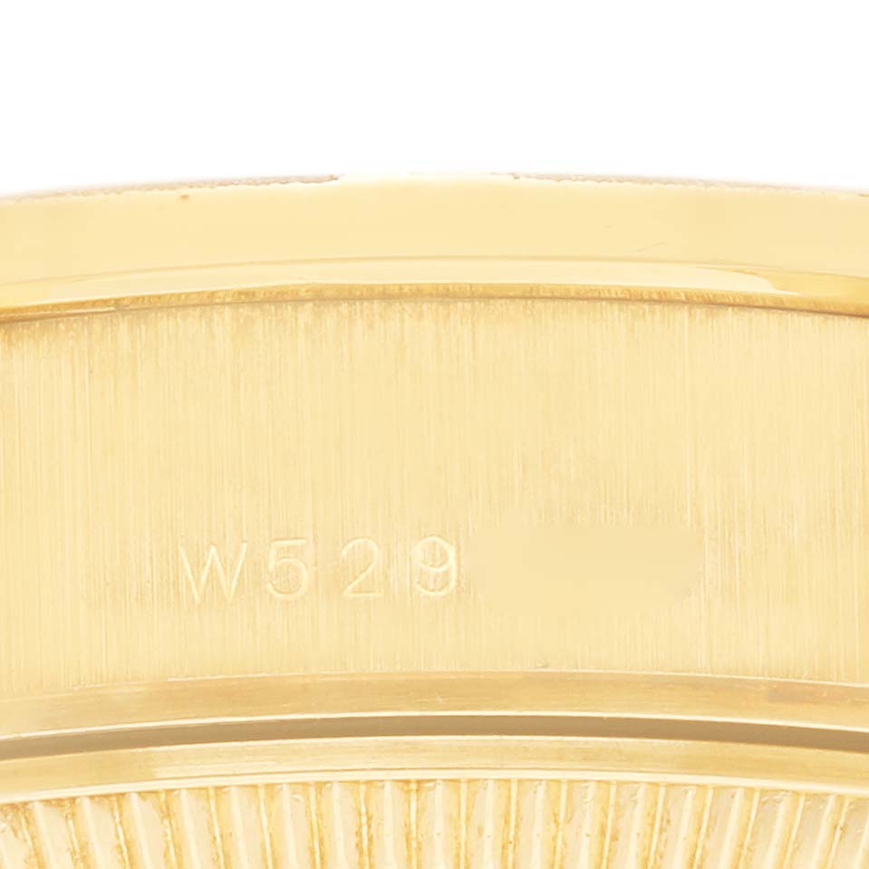 The image shows a close-up of the engraved edge of a Rolex President 69288 Women's Yellow Gold White Dial 69288 Women's Yellow Gold White Dial watch.