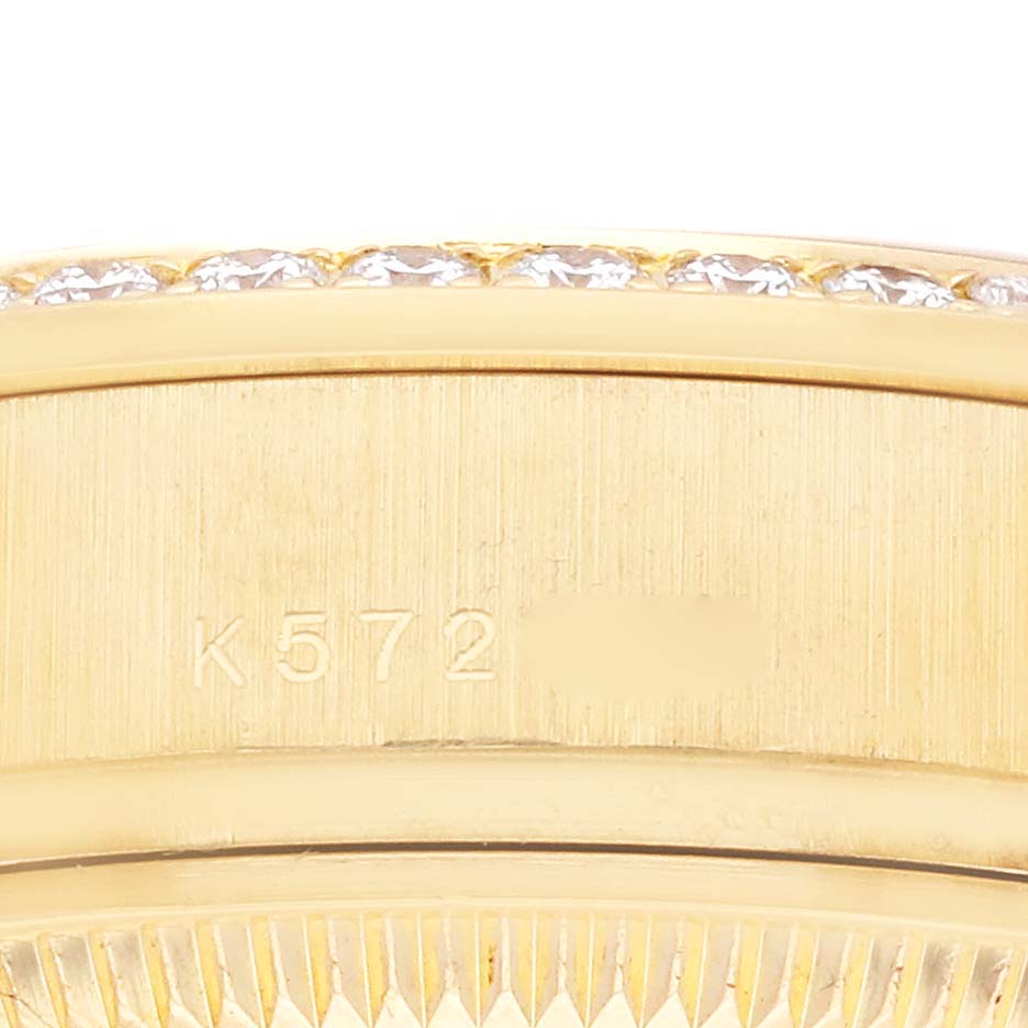 The image shows a close-up of the side of a Rolex President 179158NG Women's Yellow Gold Mother of Pearl Dial 179158NG Women's Yellow Gold Mother of Pearl Dial model, highlighting its bezel with diamonds and part of the serial number.