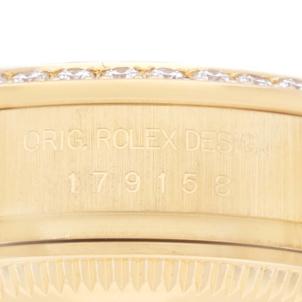 The image shows a close-up of the side of a Rolex President 179158NG Women's Yellow Gold Mother of Pearl Dial 179158NG Women's Yellow Gold Mother of Pearl Dial, highlighting the serial number and diamond-set bezel.