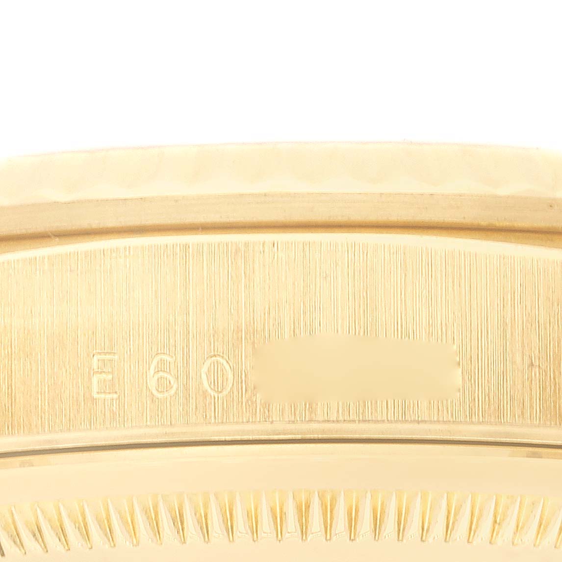 This close-up image shows the serial number and part of the bezel of the Rolex President 18238 Men
s Yellow Gold White Dial 18238 Men
s Yellow Gold White Dial model watch.