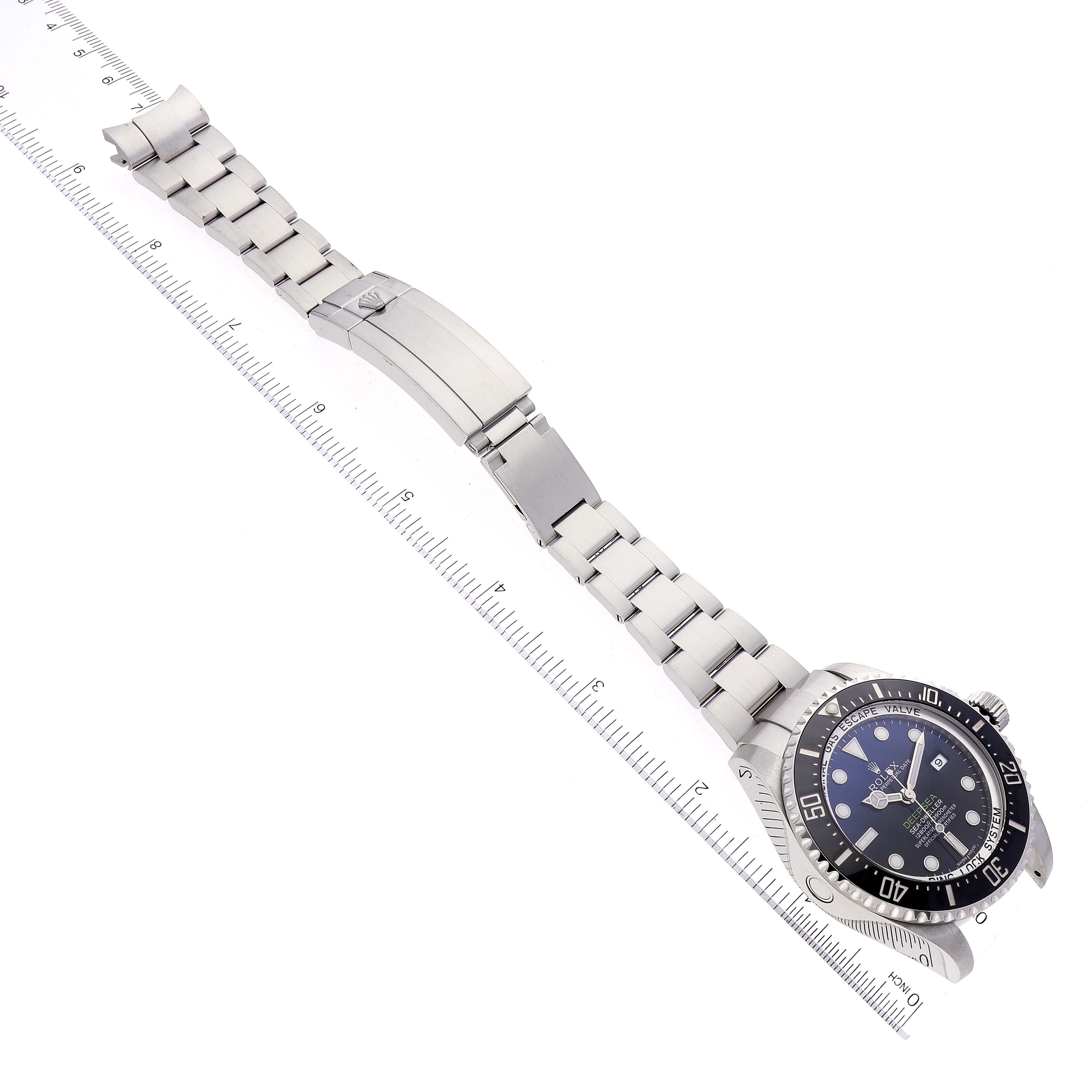 The Rolex Sea-Dweller 116660 Men's Stainless Steel Blue Dial 116660 Men's Stainless Steel Blue Dial watch is shown at an angled top-down view with its bracelet fully extended and a ruler for scale.
