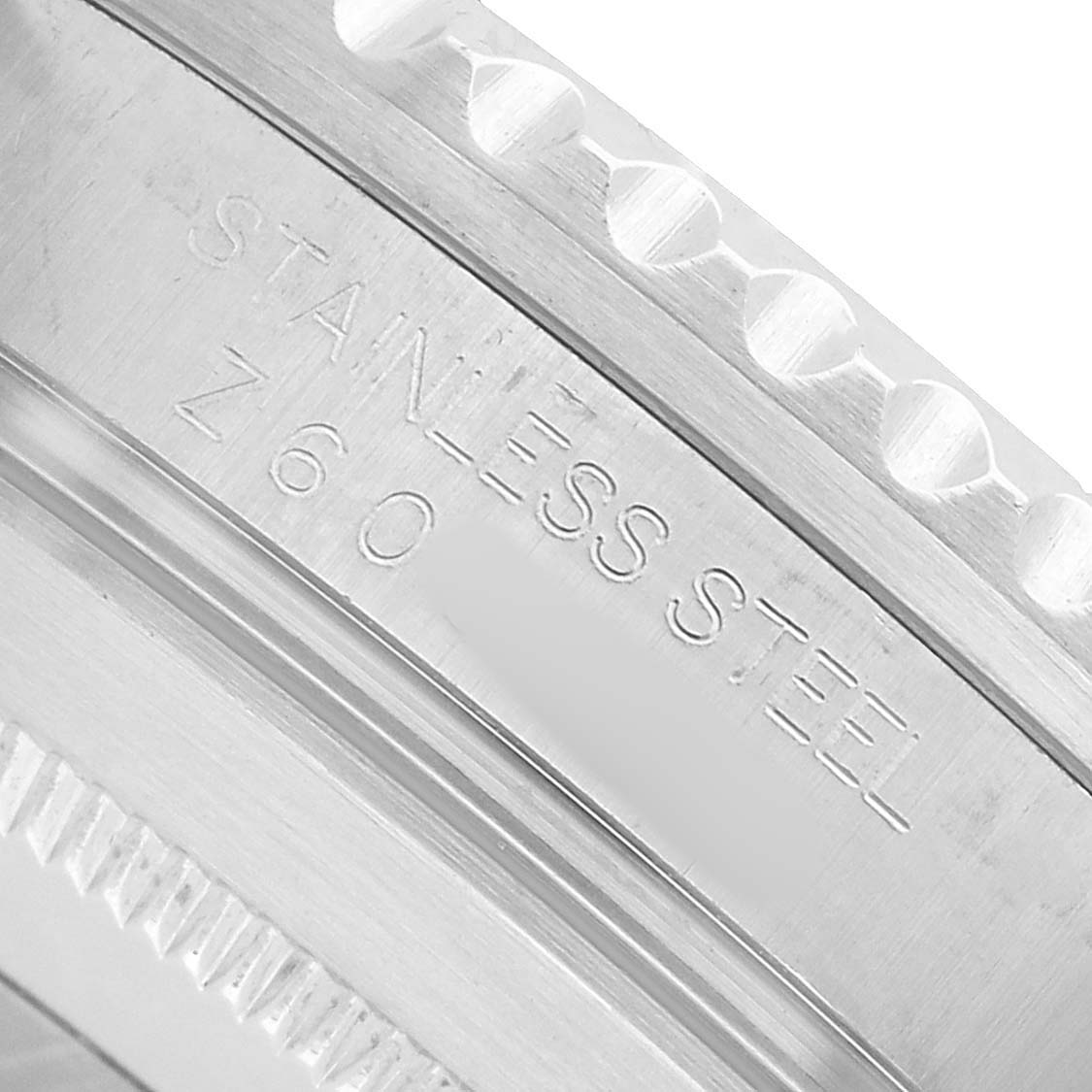 The image shows a close-up of the stainless steel bezel edge from a Rolex Submariner 16610 Men's Stainless Steel Black Dial watch, highlighting the engravings.