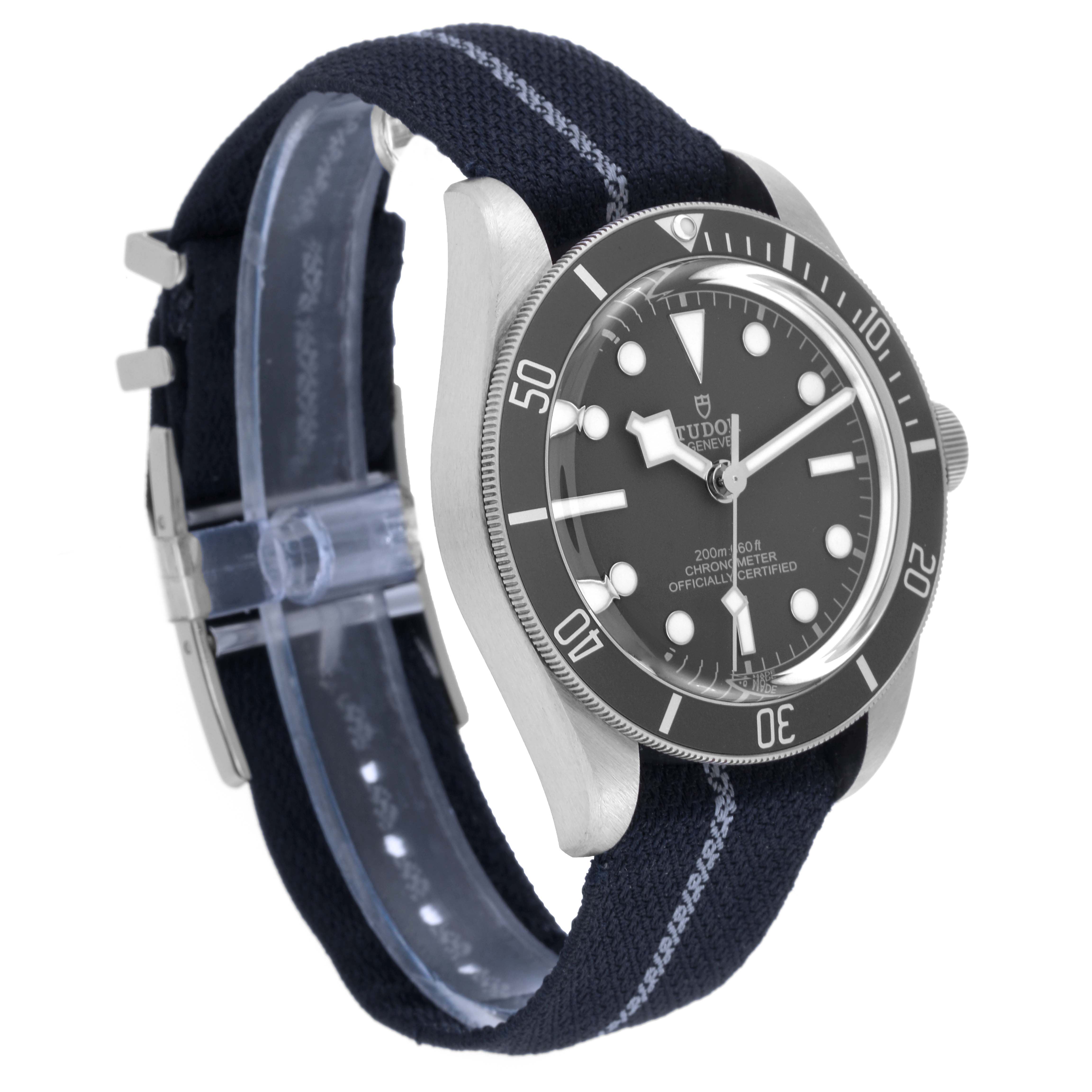 The image shows a side angle of the Tudor Heritage Black Bay 79010SG Men
s Stainless Steel Grey Dial 79010SG Men
s Stainless Steel Grey Dial watch, highlighting its dial, bezel, case, and fabric strap.