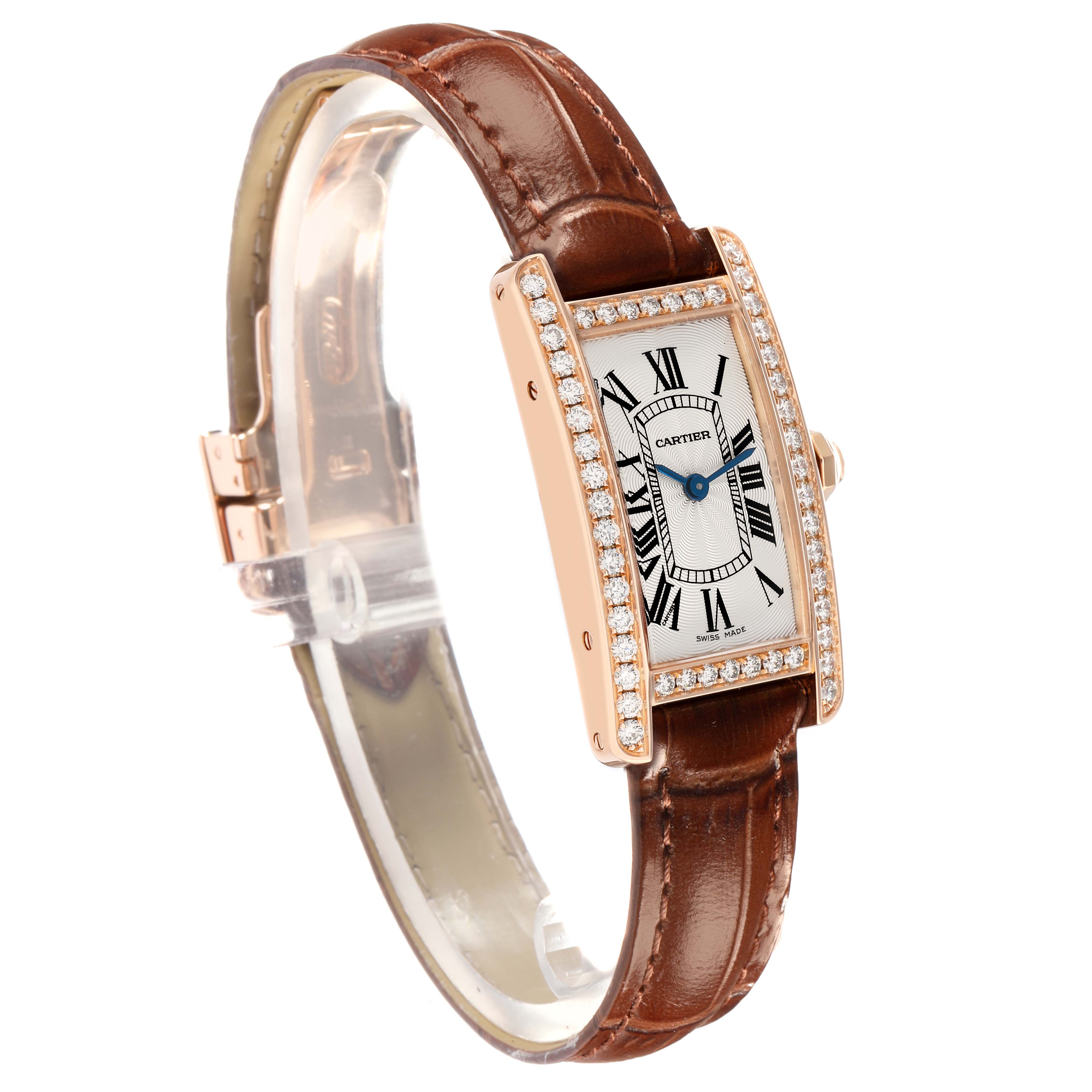 The Cartier Tank Américaine watch is angled to show its diamond-encrusted case, face with Roman numerals, and brown leather strap.