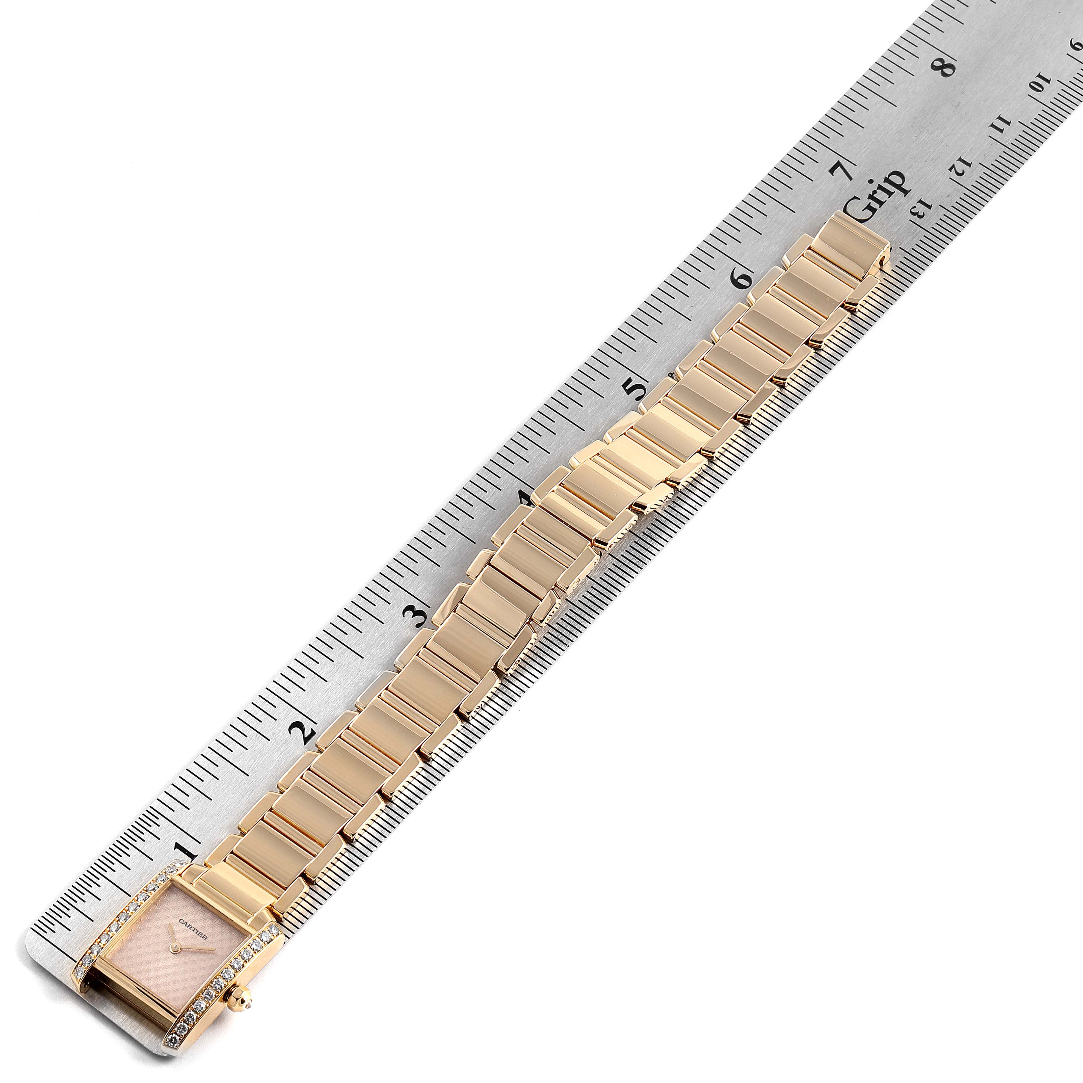 The image shows a horizontal view of a Cartier Tank Francaise 2403 Women's Yellow Gold Pink Dial 2403 Women's Yellow Gold Pink Dial watch, focusing on its gold bracelet and face, alongside a ruler for scale.
