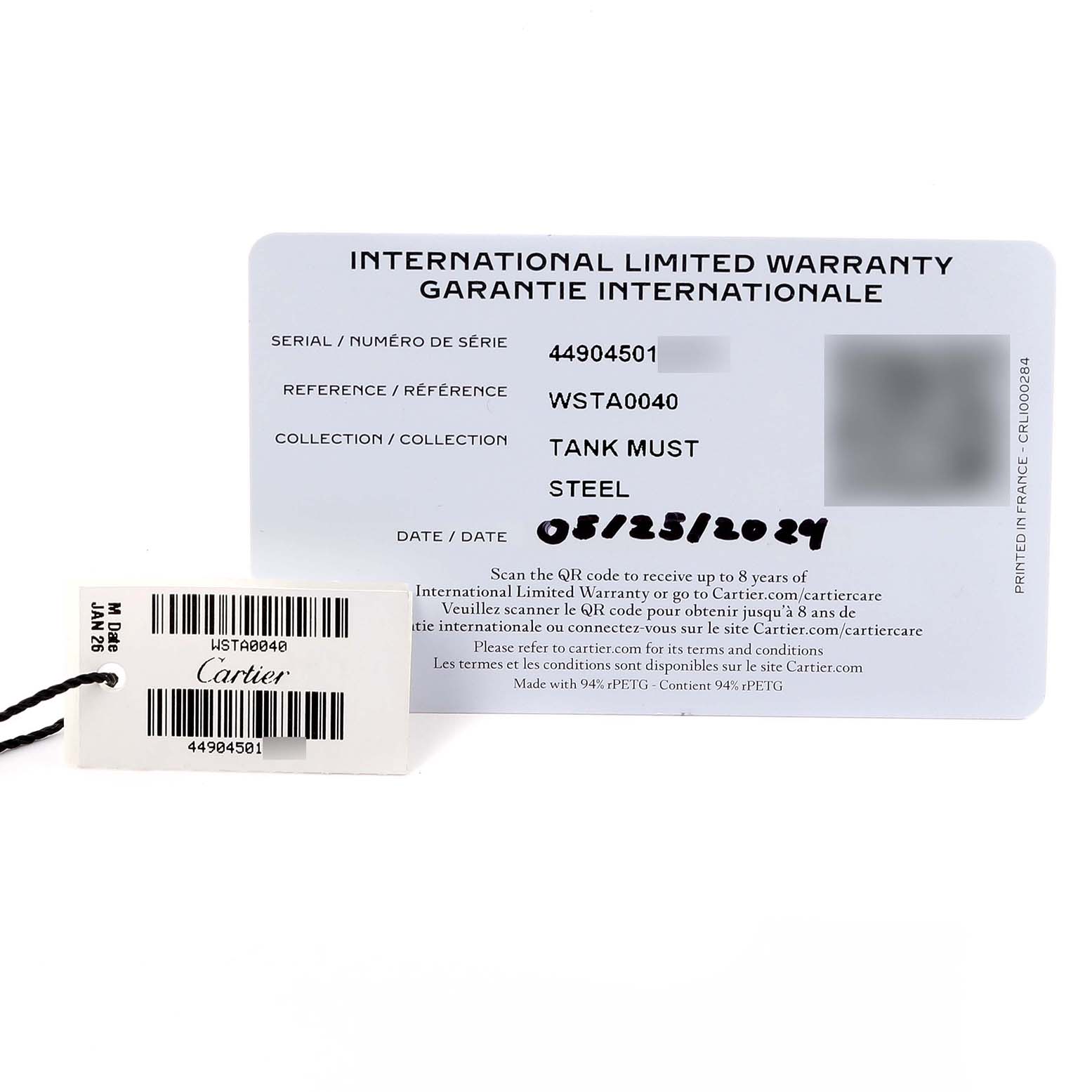 The image shows a warranty card and a tag for the Cartier Tank Must WSTA0040 Men's Stainless Steel Silver Dial WSTA0040 Men's Stainless Steel Silver Dial model.