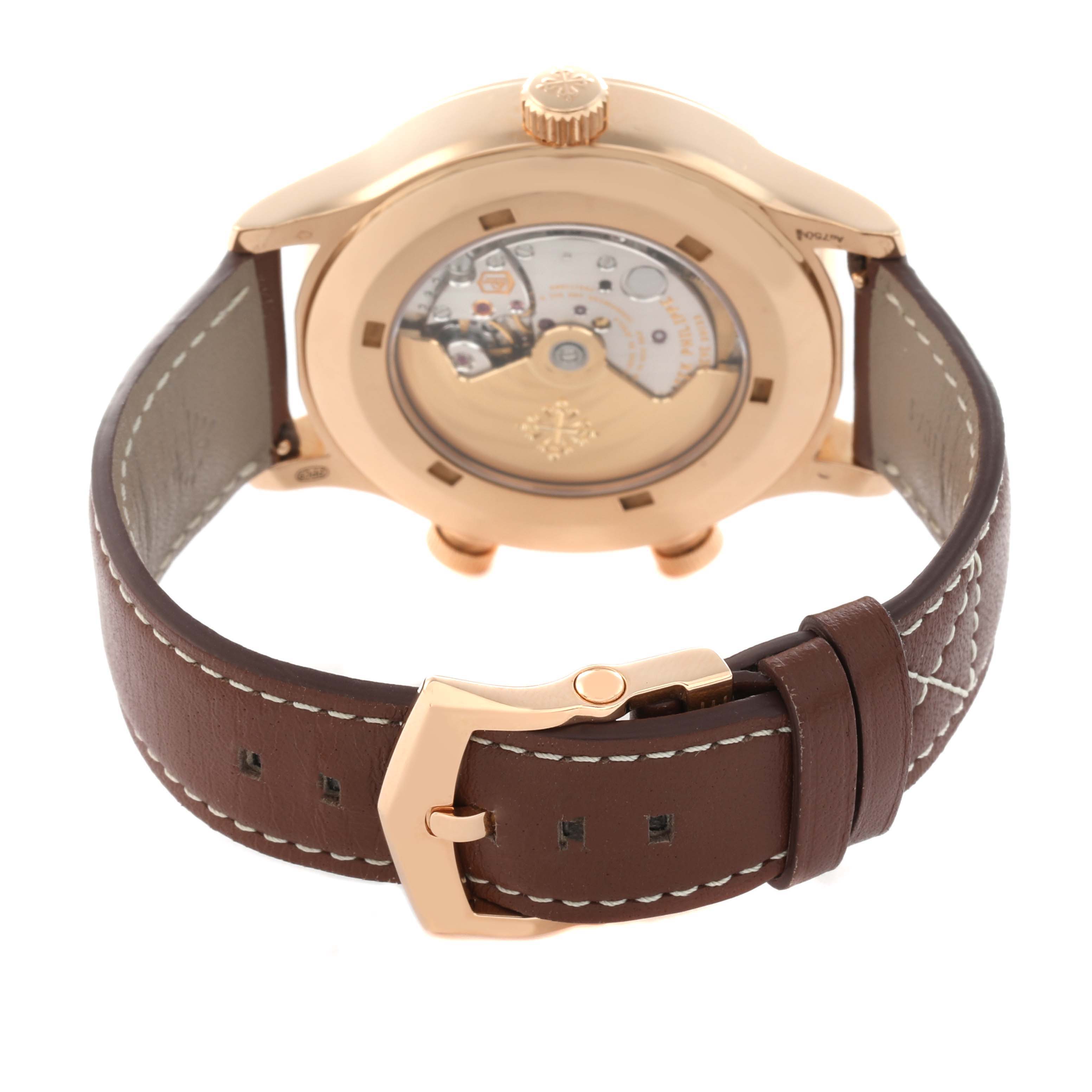 The image shows the back of a Patek Philippe Calatrava 5524R-001 Men
s Rose Gold Brown Dial watch, highlighting its movement and leather strap with a buckle.
