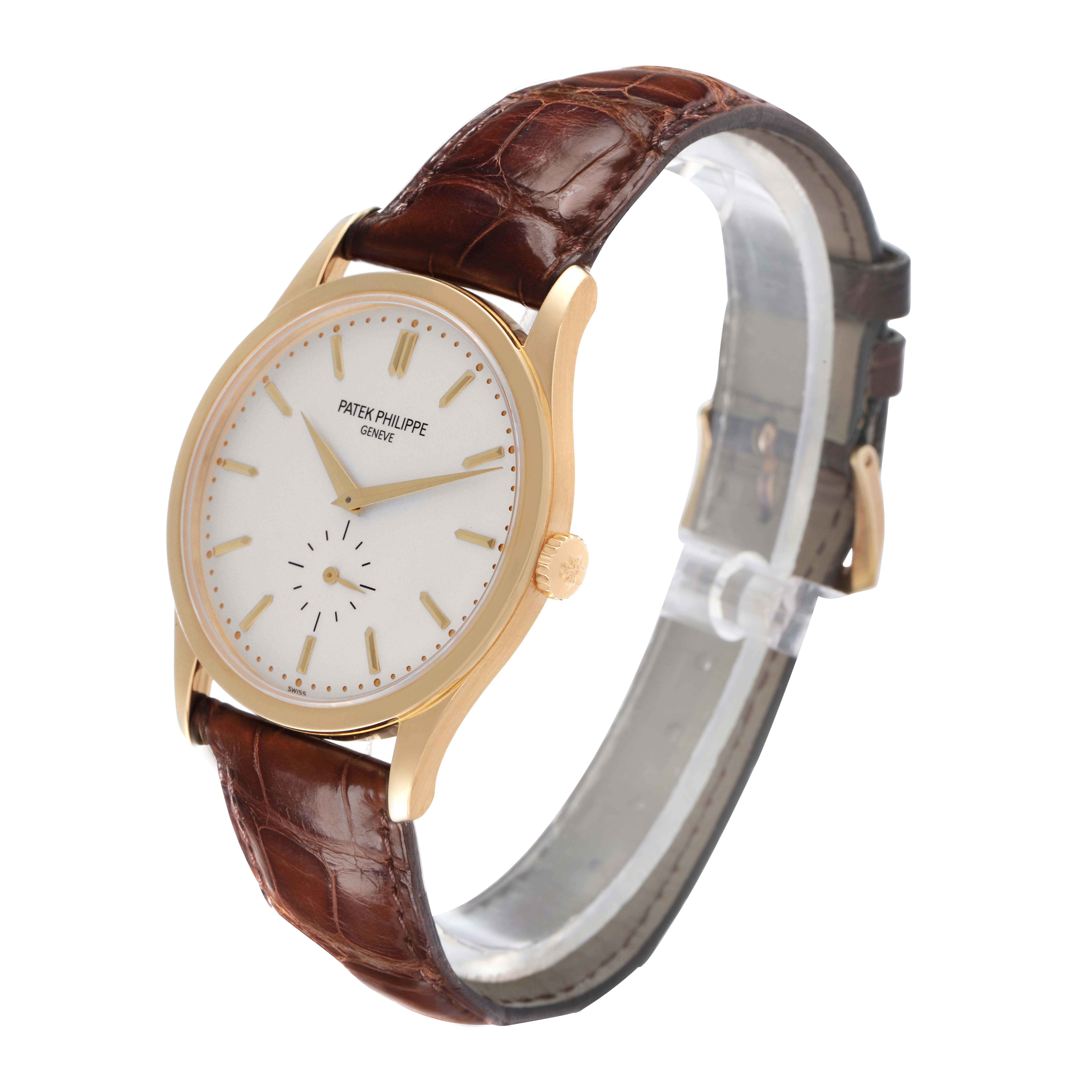 The Patek Philippe Calatrava 5196J watch is shown in a three-quarter angle, highlighting its yellow gold case, silver dial, and leather strap.