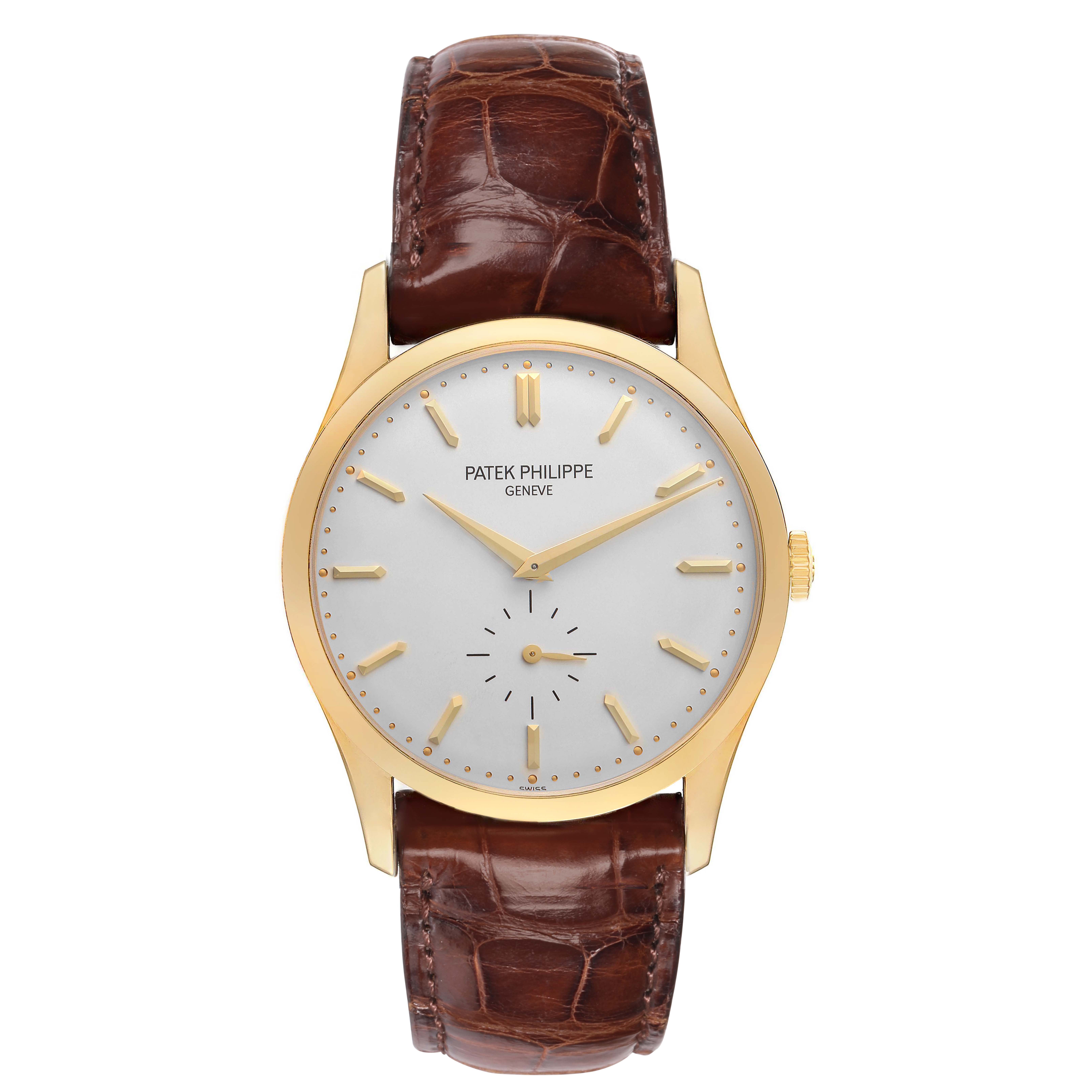 The Patek Philippe Calatrava 5196J is shown from the front, displaying its yellow gold case, silver dial, and leather strap.