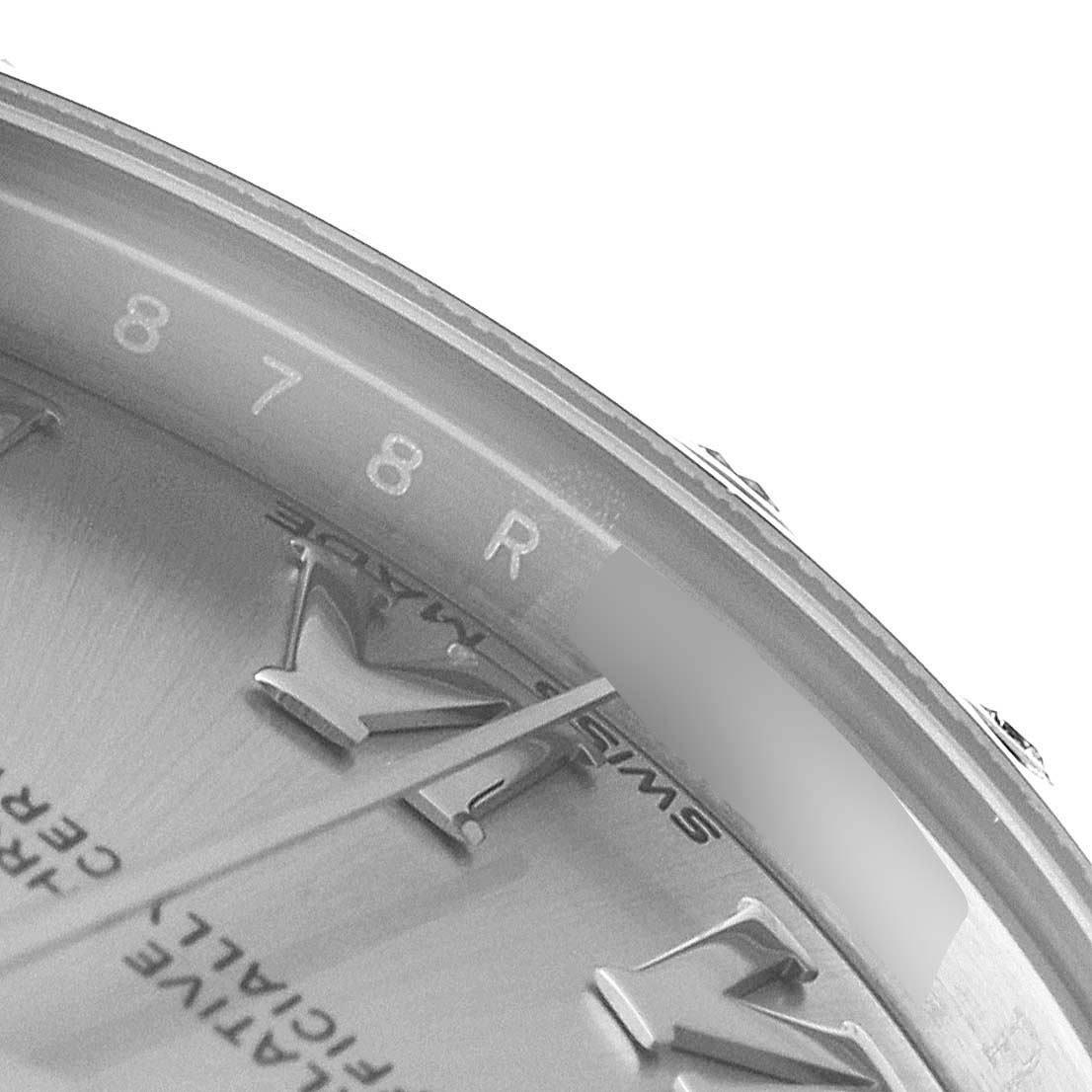 The image shows a close-up angle of the dial and partial bezel of a Mid-Size Rolex watch, focusing on the hour markers and part of the serial number.