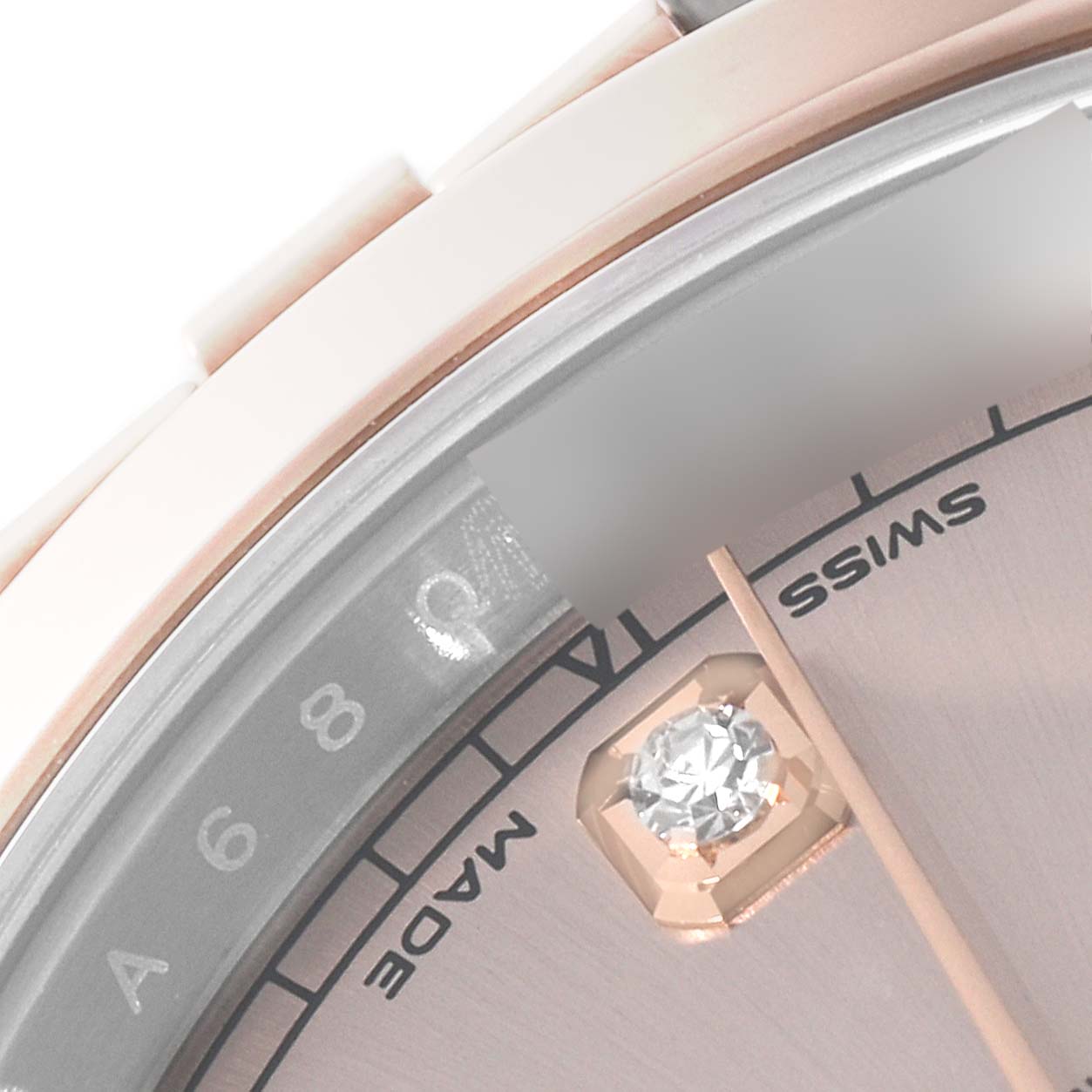This close-up image of a Rolex Datejust 41 126301 Men's Steel and Gold (two tone) Pink Dial 126301 Men's Steel and Gold (two tone) Pink Dial watch shows part of its dial, indices, and the "Swiss made" inscription.