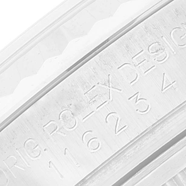 This close-up shows the engraved serial number and "ROLEX DESIGN" text inside the case of a Rolex Datejust 116234 Men's Stainless Steel Black Dial 116234 Men's Stainless Steel Black Dial watch.