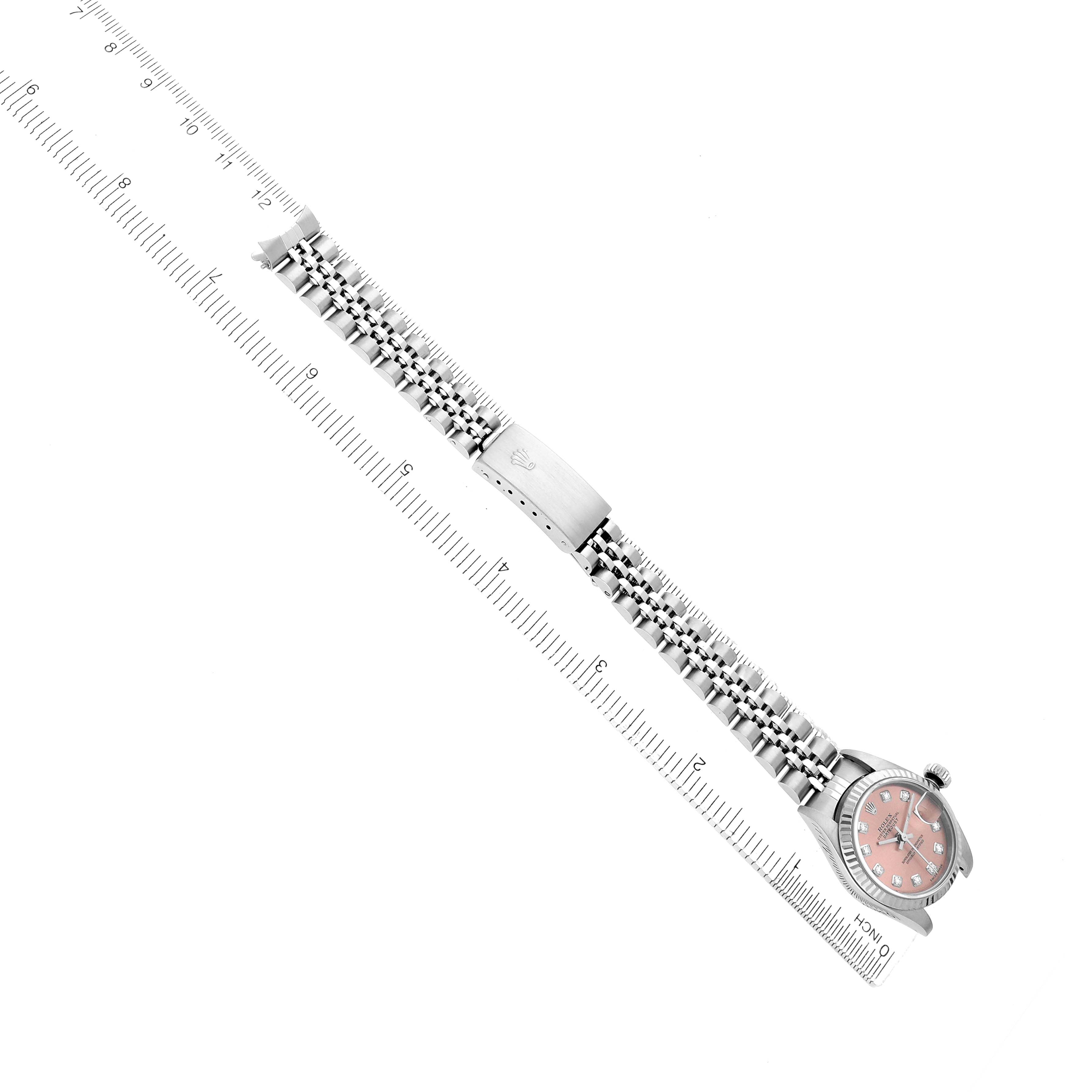 The image shows a Rolex Datejust 79174 Men
s Stainless Steel Pink Dial watch laid flat with its bracelet fully extended next to a ruler, featuring the face, bracelet, and clasp.