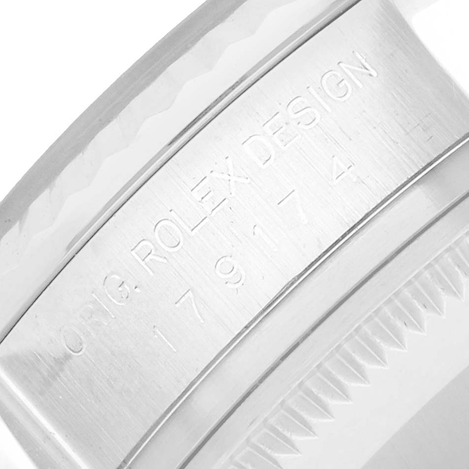 The image shows part of the case back of a Rolex Datejust 179174 Women
s Stainless Steel Silver Dial, highlighting the engravings and fluted bezel.