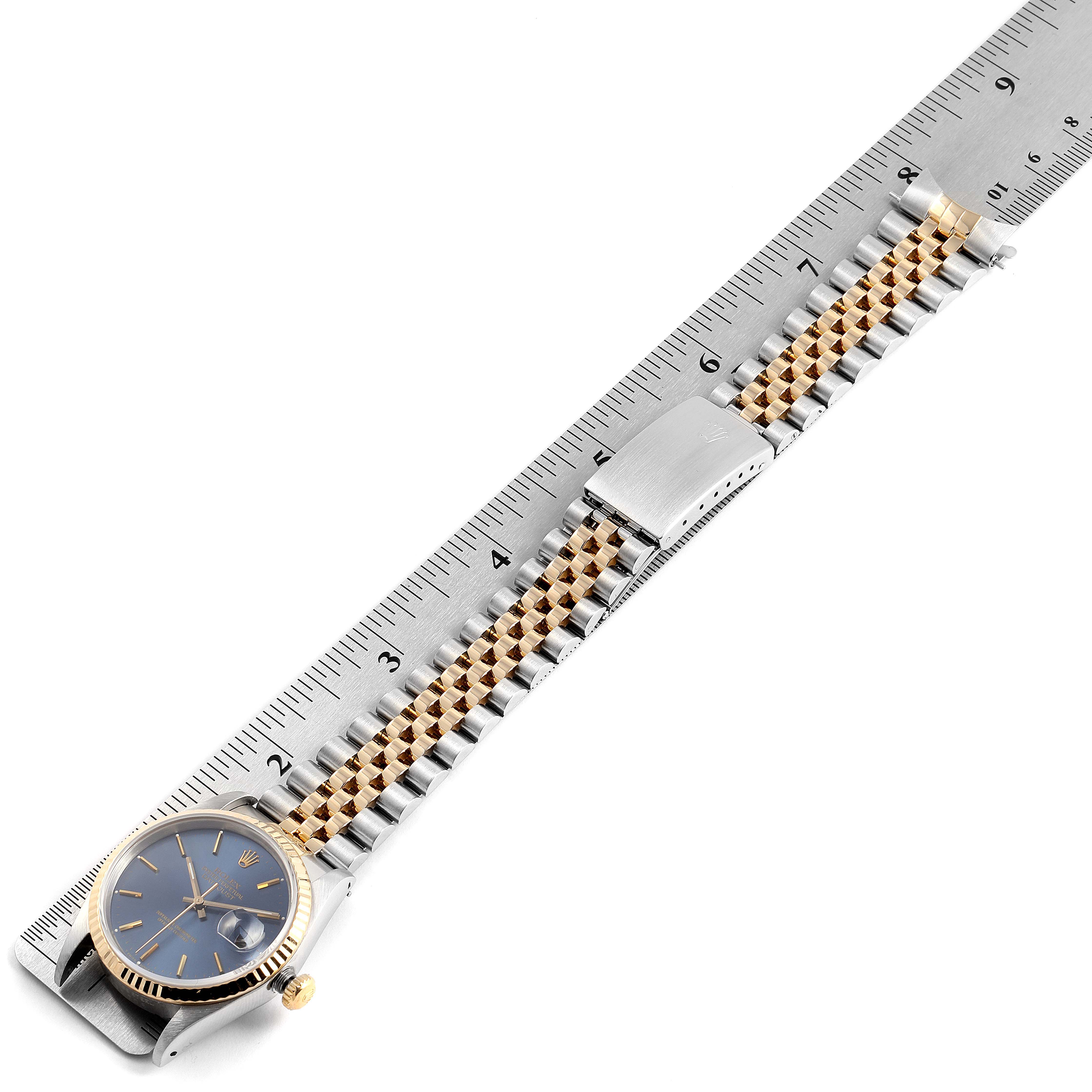 The image shows a Rolex Datejust 16233 Men's Steel and Gold (two tone) Blue Dial 16233 Men's Steel and Gold (two tone) Blue Dial watch with a blue dial and two-tone metal bracelet, measured against a ruler.
