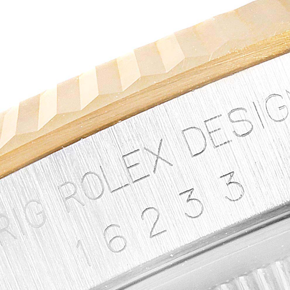 The image shows a close-up of the bezel and engraved case side of a Rolex Datejust 16233 Men's Steel and Gold (two tone) Blue Dial 16233 Men's Steel and Gold (two tone) Blue Dial watch.