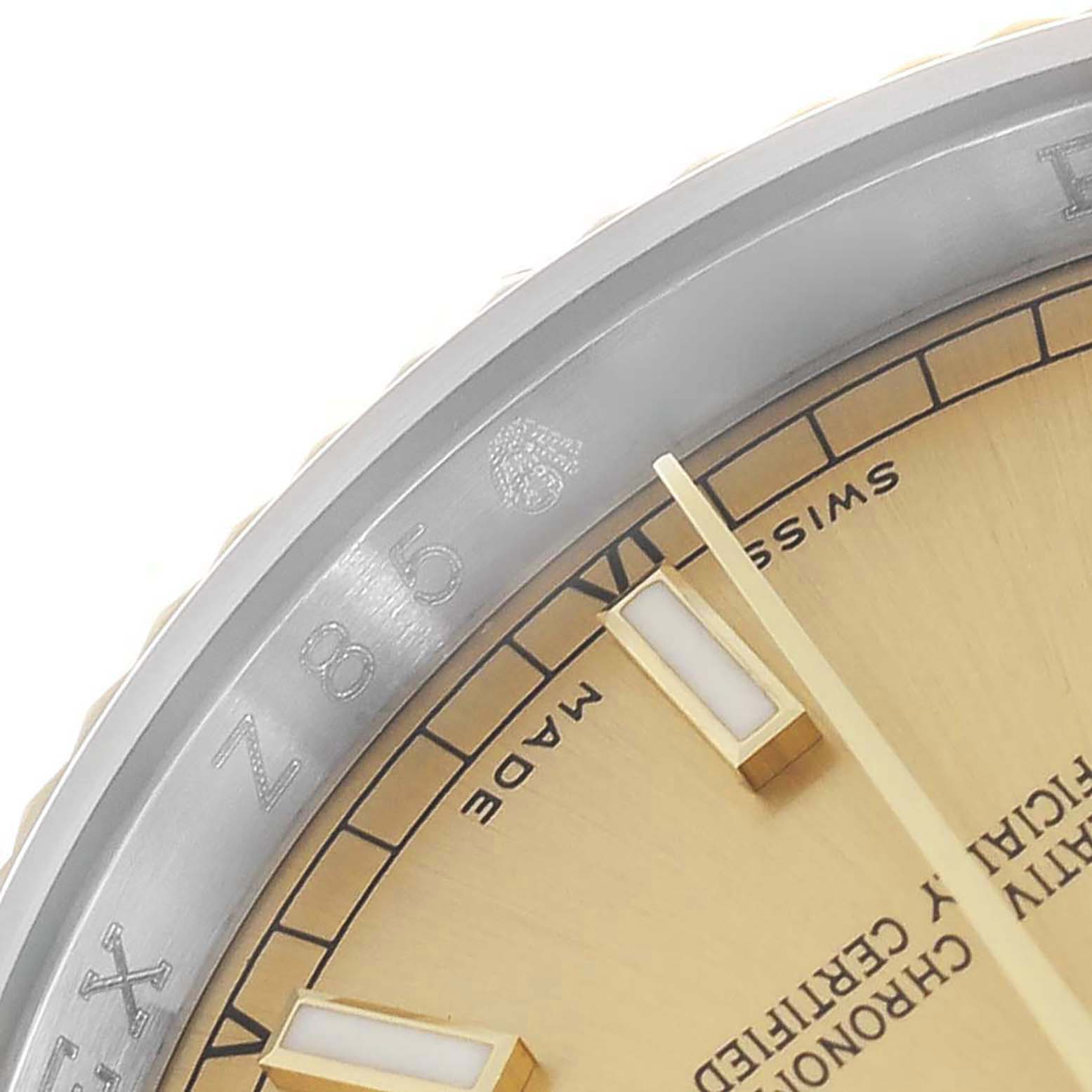 The image shows a close-up of the Rolex Datejust 116233 Men
s Steel and Gold (two tone) Champagne Dial watch
s dial and bezel, highlighting the hour markers and text.