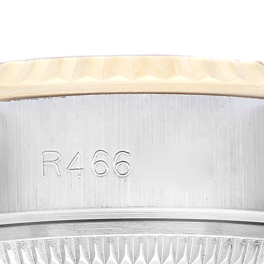 The image shows a close-up of the side of a Rolex Datejust 69173 Women
s Steel and Gold (two tone) Champagne Dial, highlighting the fluted bezel and engraved serial number.