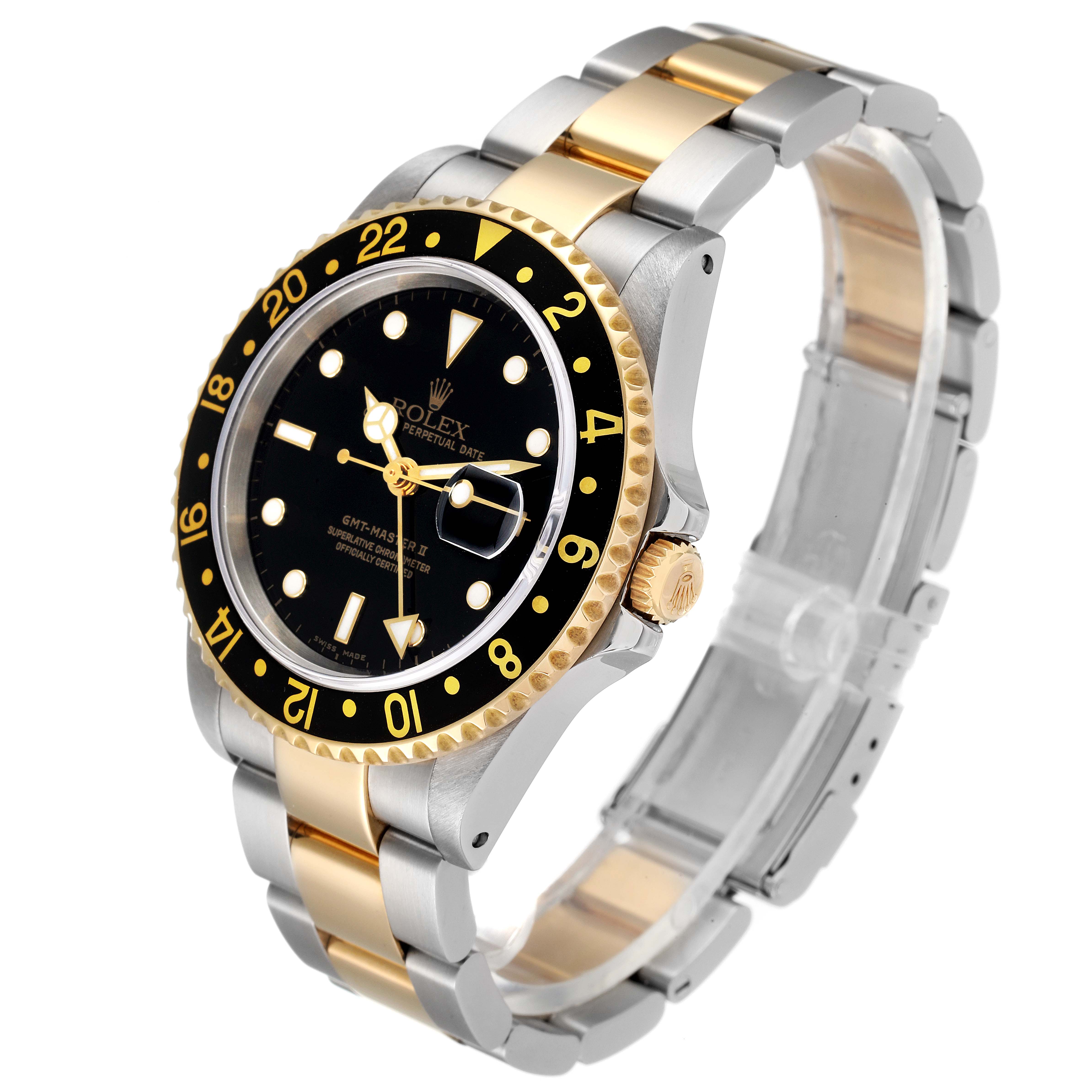 The Rolex GMT-Master 16713 Men's Steel and Gold (two tone) Black Dial 16713 Men's Steel and Gold (two tone) Black Dial watch is shown at an angled view, displaying its black dial, two-tone bracelet, and gold bezel with numerals.