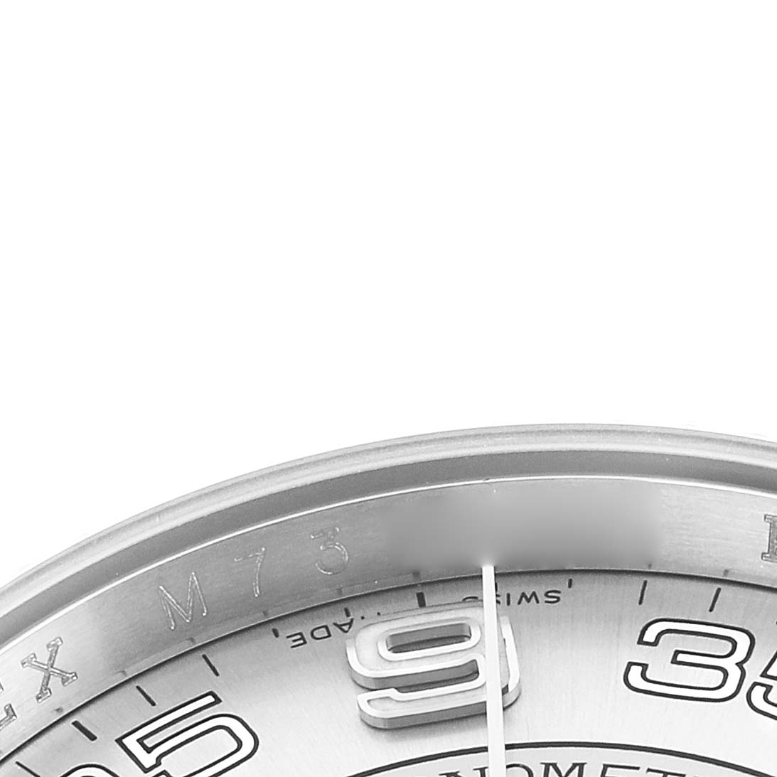 The image shows a close-up of the Rolex Oyster Perpetual 116034 Men
s Stainless Steel Blue Dial
s bezel, part of the dial, and indices.