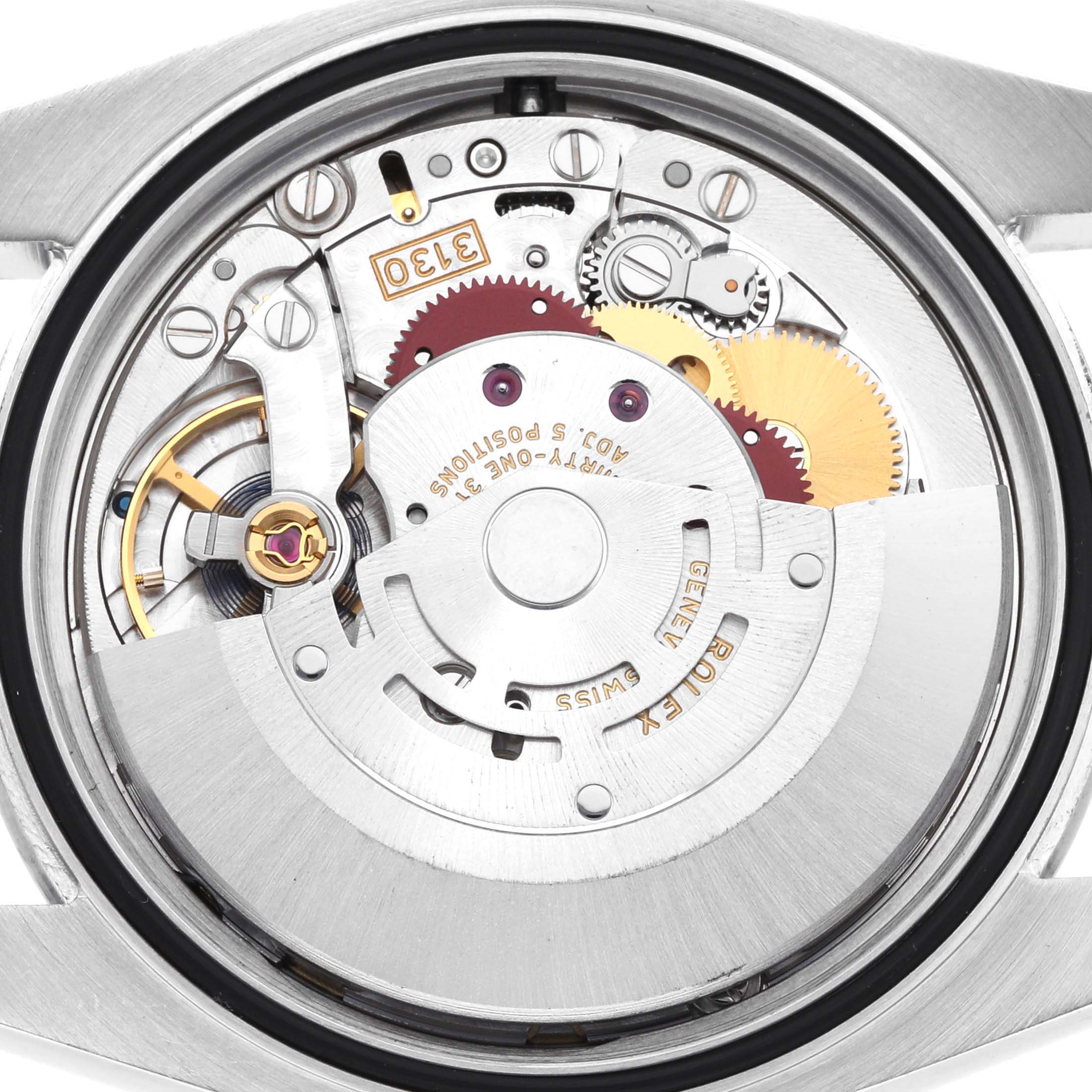 The image shows the movement of a Rolex Oyster Perpetual 116000 Men's Stainless Steel Blue Dial watch, highlighting gears, springs, and the oscillating weight from a back view.