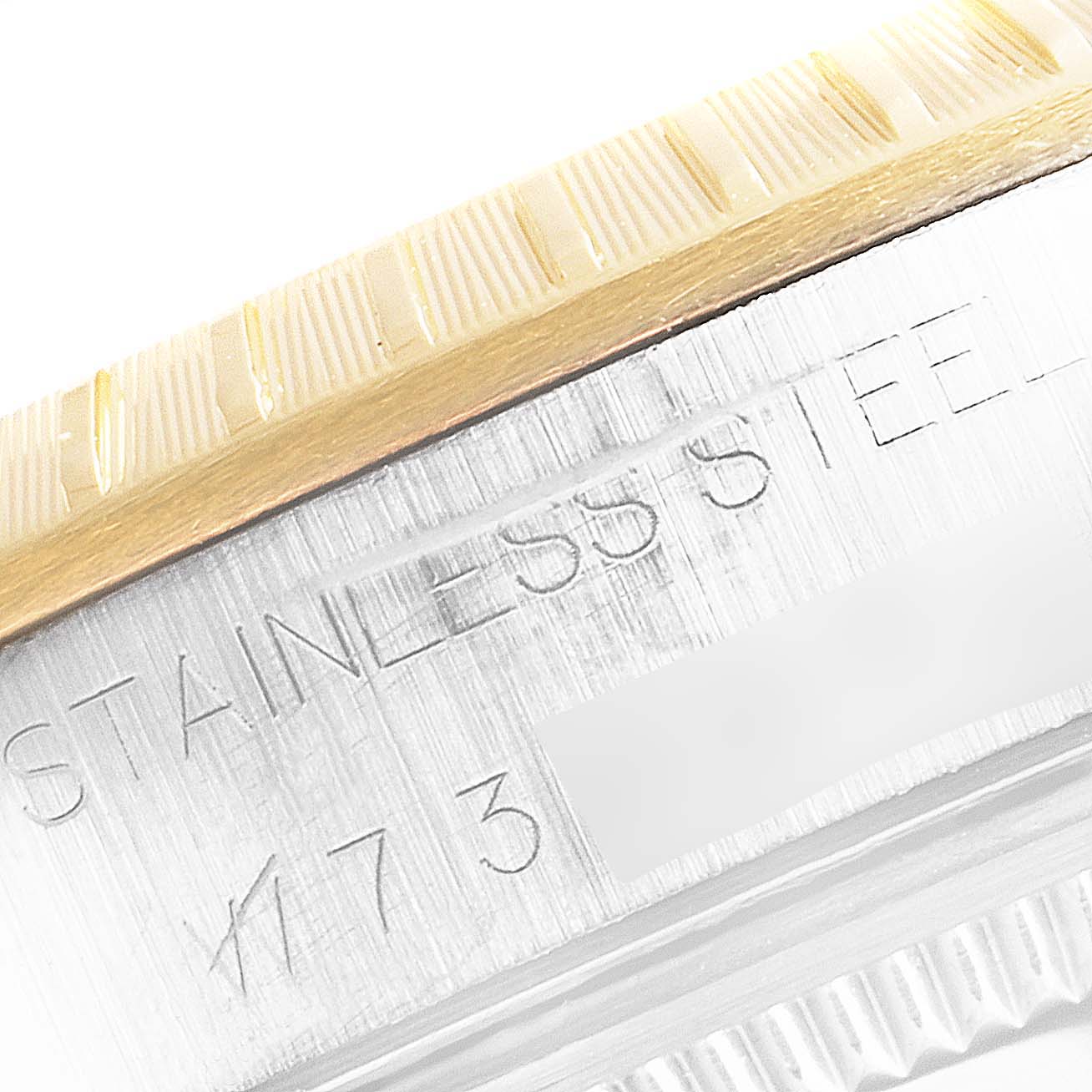 This close-up angle shows the bezel and case details of the Rolex Oyster Perpetual 14203 Men's Steel and Gold (two tone) White Dial 14203 Men's Steel and Gold (two tone) White Dial, including the "STAINLESS STEEL" engraving.