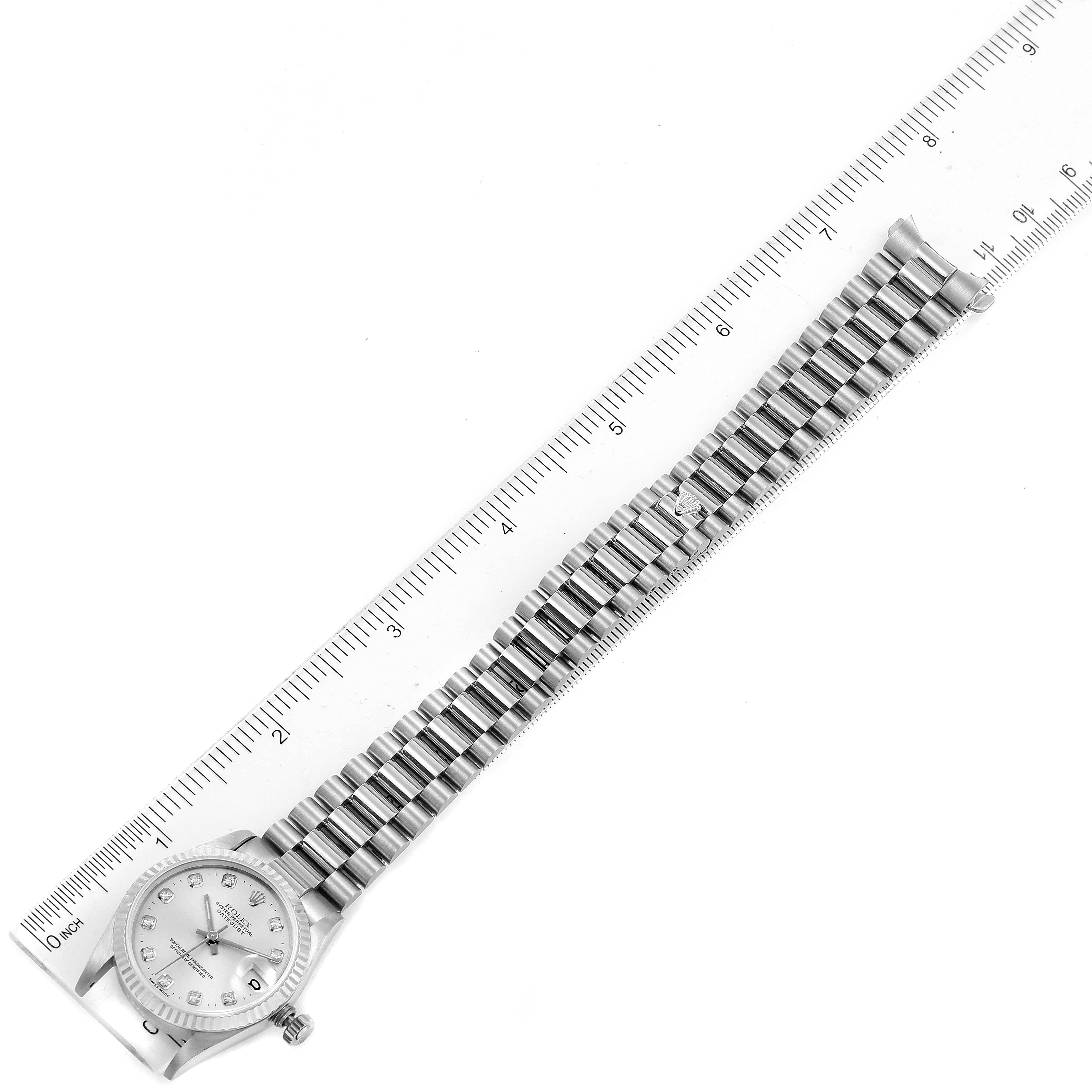 The image shows a Rolex President 68279 Women
s White Gold Silver Dial 68279 Women
s White Gold Silver Dial model watch laid flat next to a ruler for size reference, displaying the entire bracelet and watch face.