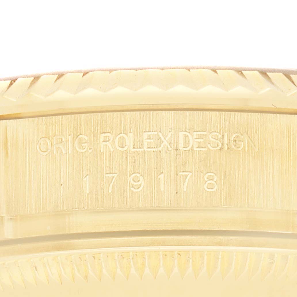 The image shows a close-up of the side of a Rolex President 179178 Women
s Yellow Gold Champagne Dial model, displaying the engraved model number and "ORIG. ROLEX DESIGN".