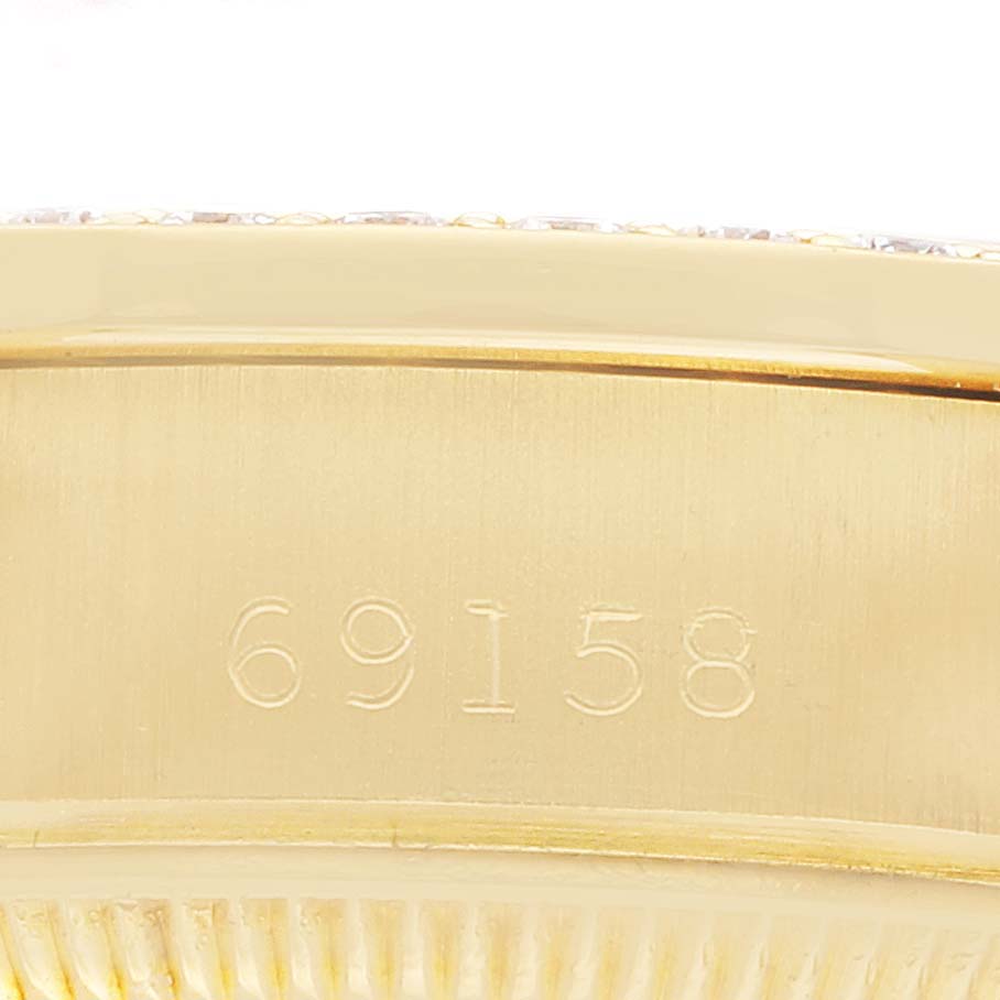 The image shows a close-up of the case back edge of a Rolex President 69158 Women
s Yellow Gold Champagne Dial watch, focusing on the engraved model number.