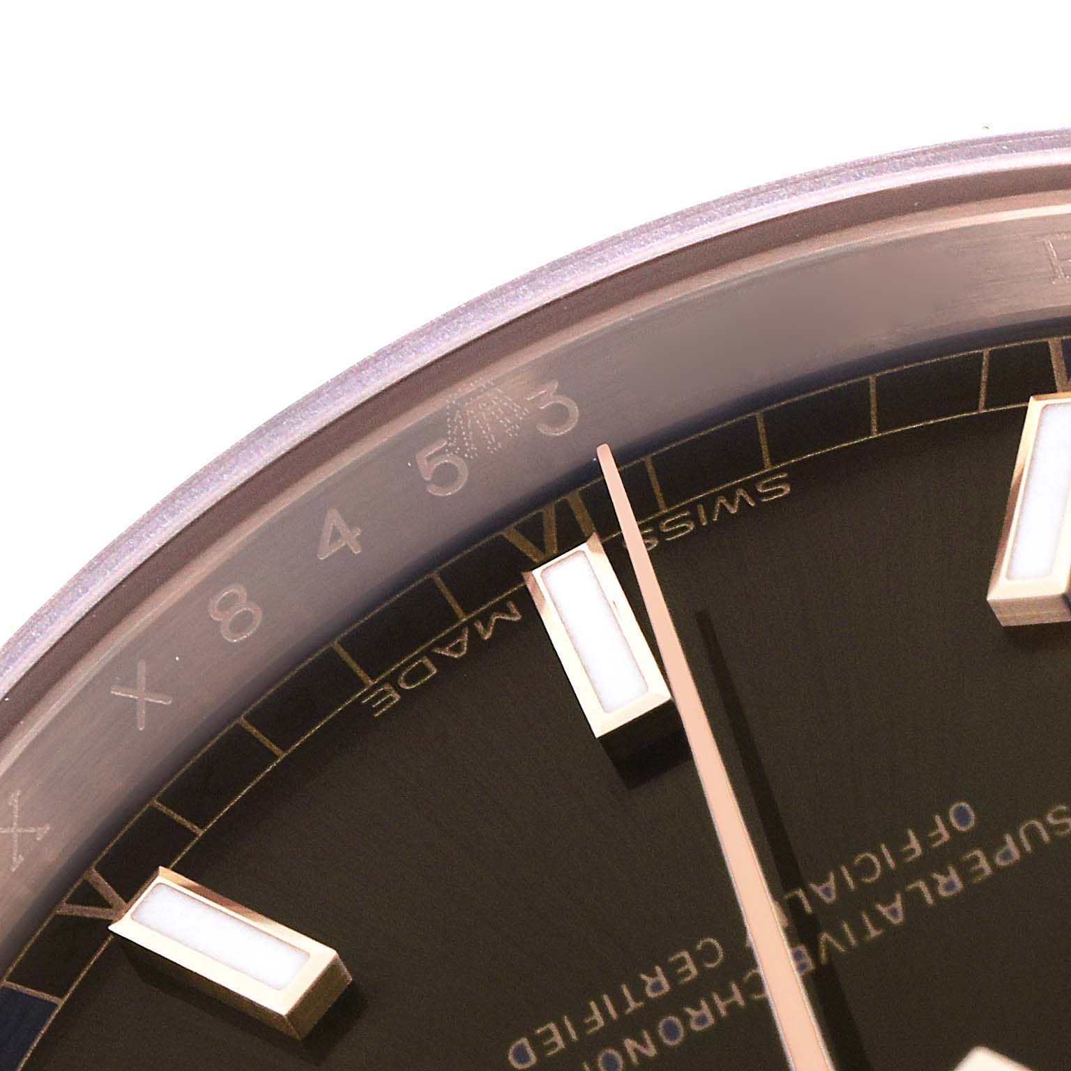 This close-up image of the Rolex President 118135 Men's Rose Gold Brown Dial 118135 Men's Rose Gold Brown Dial model watch shows part of the dial and bezel, highlighting the hour markers and part of the second hand.