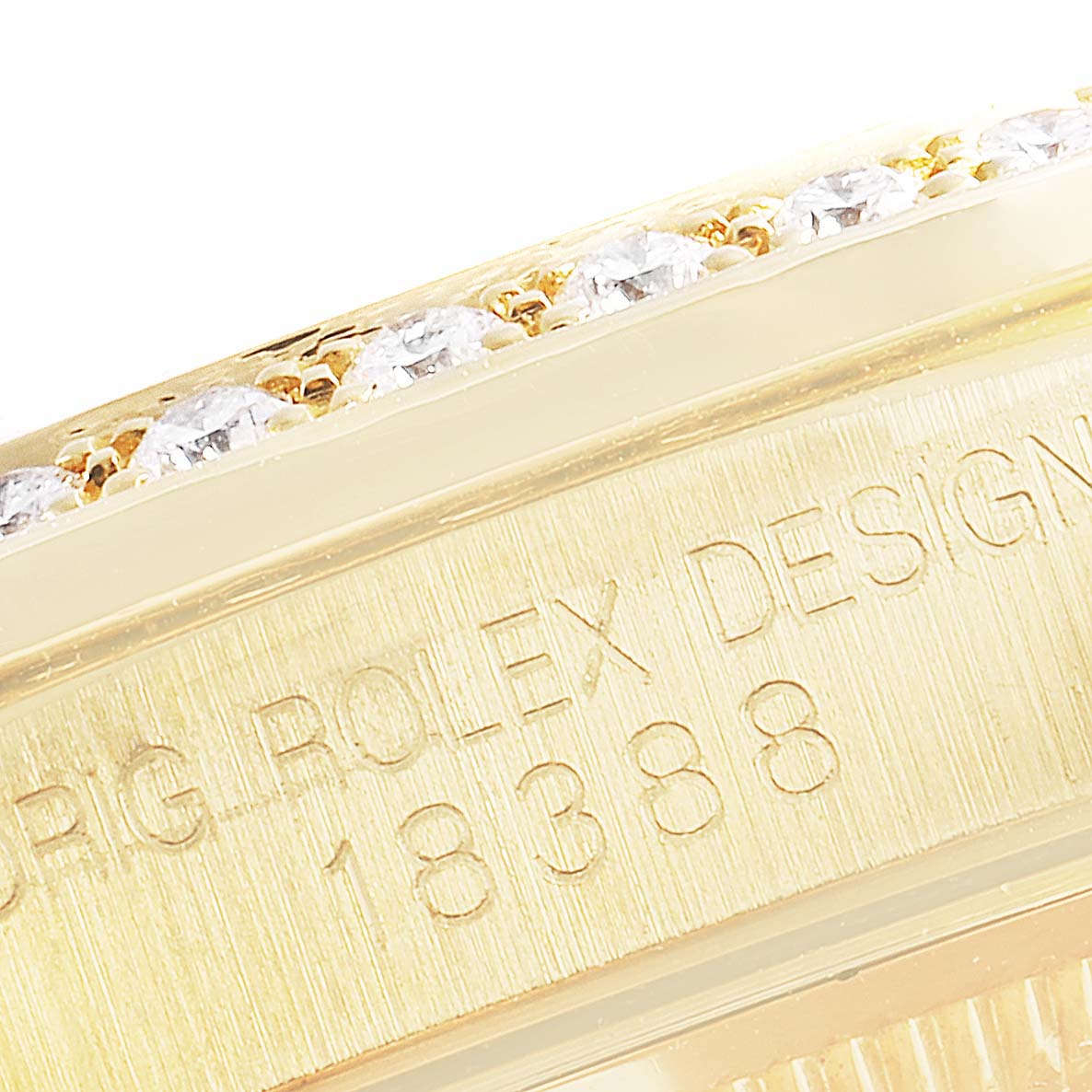 This close-up image shows the side of the bezel and part of the casing of the Rolex President 18388 Men
s Yellow Gold Champagne Dial 18388 Men
s Yellow Gold Champagne Dial model, revealing diamond detailing and the model number.