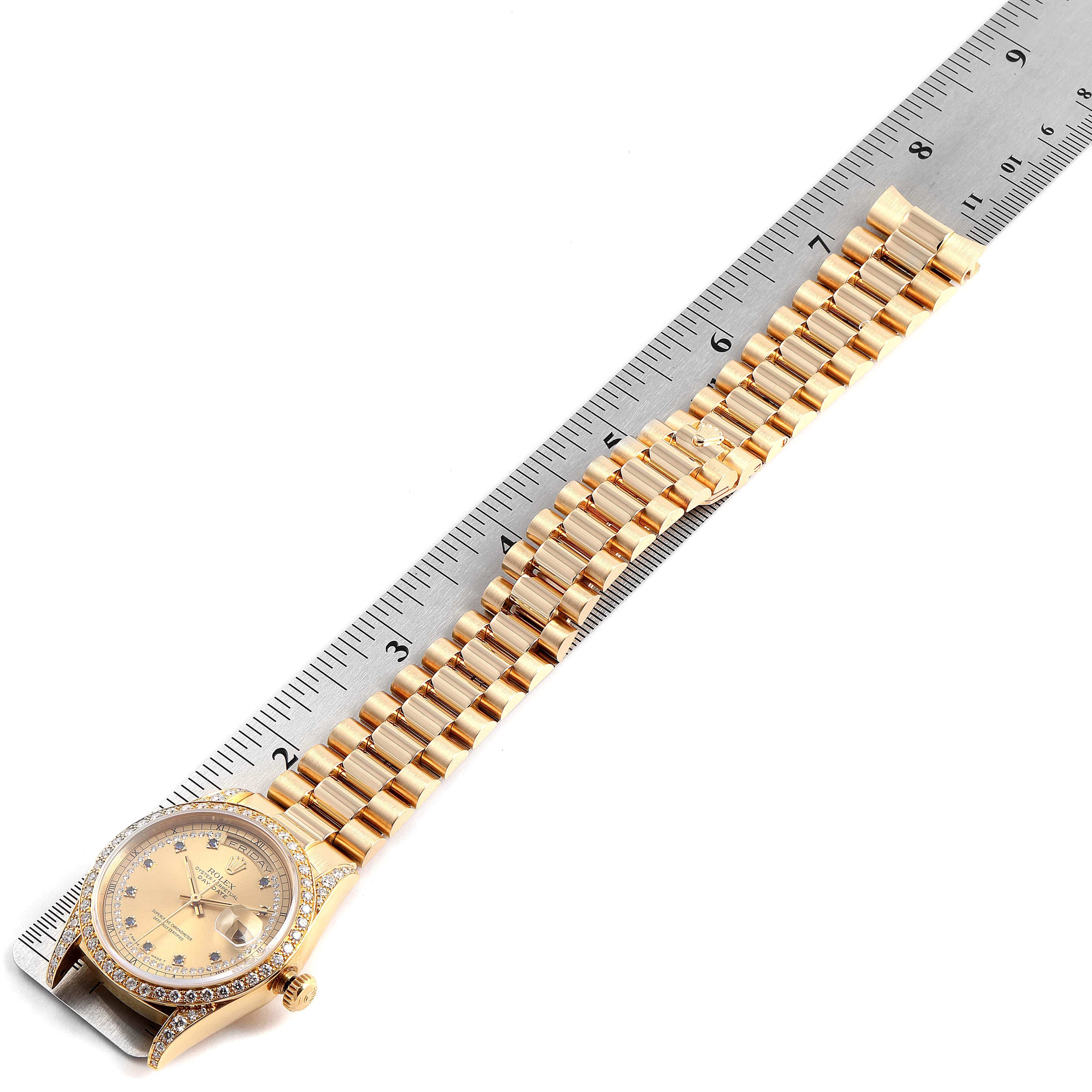 The Rolex President 18388 Men
s Yellow Gold Champagne Dial 18388 Men
s Yellow Gold Champagne Dial model watch is shown from a top-down angle, showcasing its full bracelet and face beside a ruler for scale.