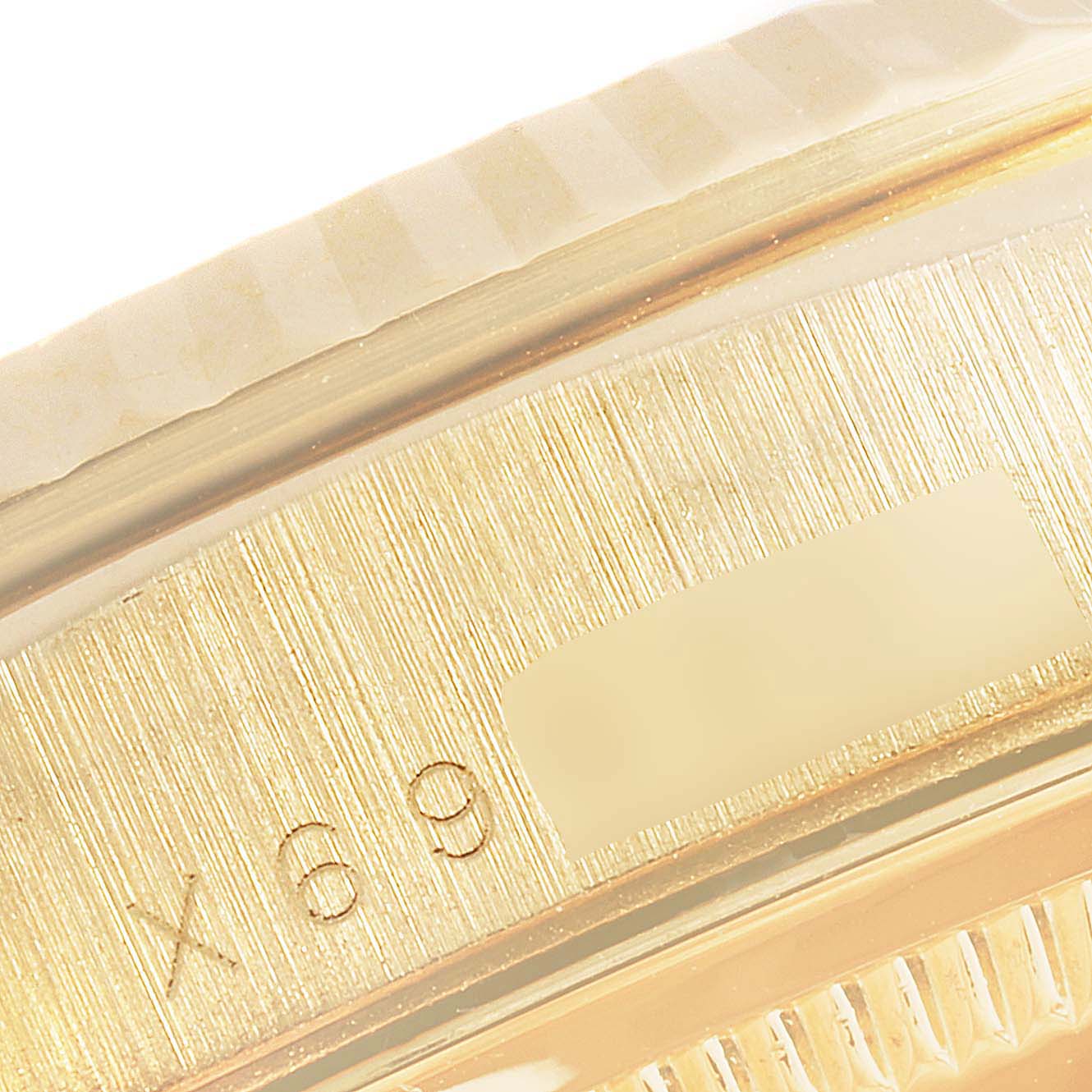 The image shows a close-up of the case side of a Rolex President 18238 Men
s Yellow Gold Champagne Dial 18238 Men
s Yellow Gold Champagne Dial watch, highlighting the serial number and part of the fluted bezel.