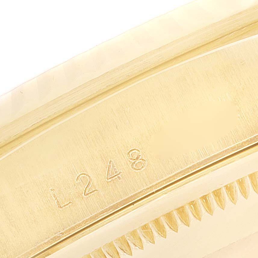 The image shows a close-up of the side of the Rolex President 18238 Men's Yellow Gold Champagne Dial 18238 Men's Yellow Gold Champagne Dial model watch, highlighting serial numbers engraved on the gold surface.