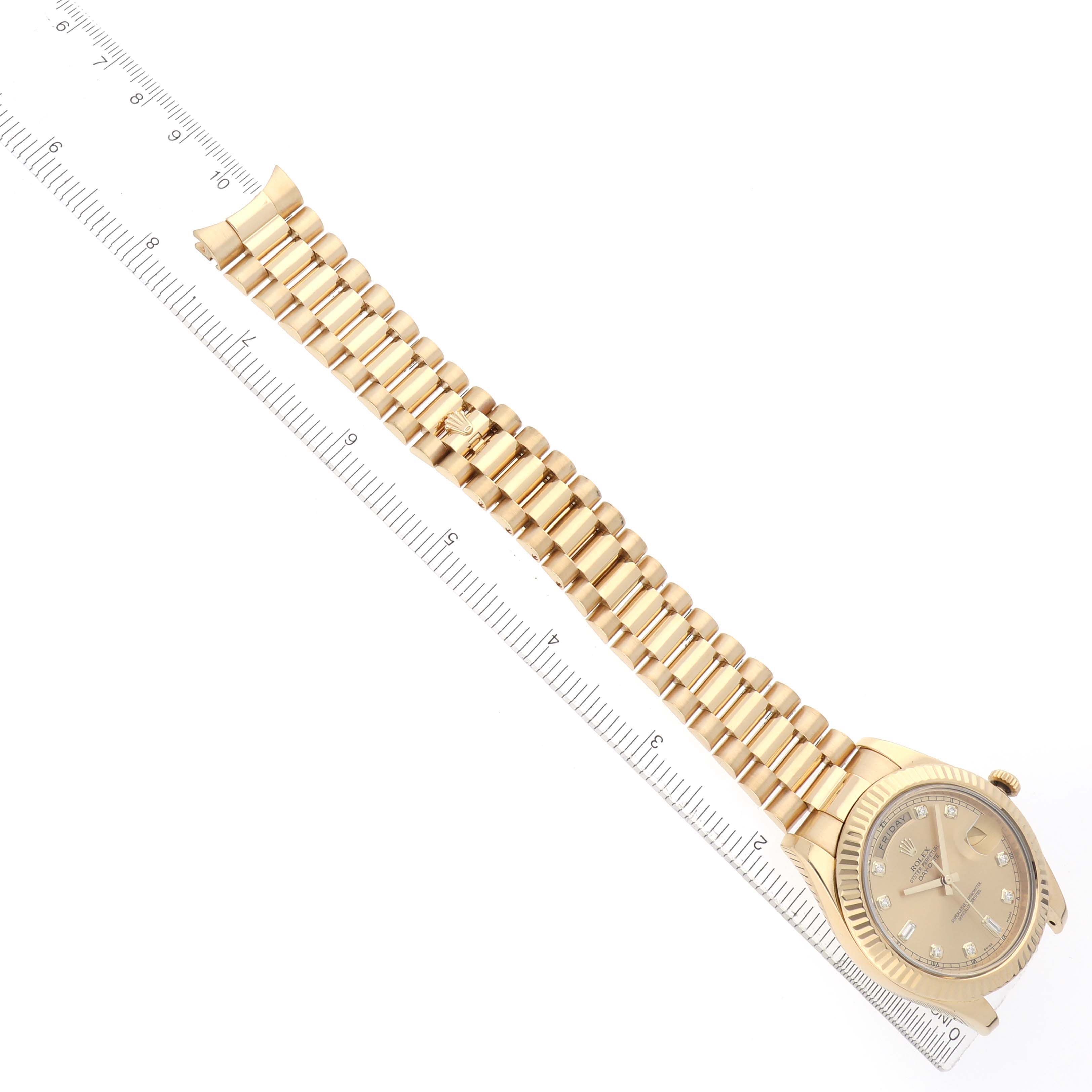 The Rolex President 218238 Men
s Yellow Gold Champagne Dial model watch is shown from an overhead angle, displaying the full bracelet alongside a ruler.