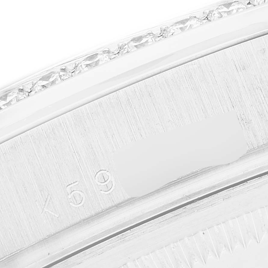 The image shows a close-up angle of the Rolex President 118346 Men
s Platinum Silver Dial model
s case edge, detailing its texture and serial number engravings.