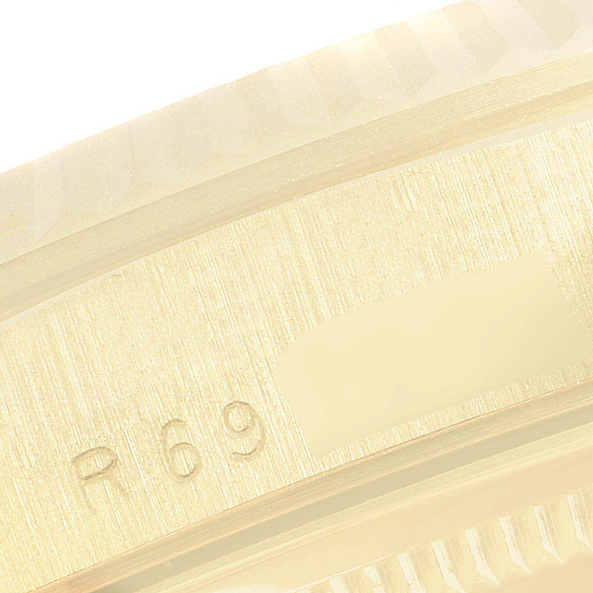 This image shows a close-up of the side edge of a Rolex President 18238 Men's Yellow Gold Champagne Dial 18238 Men's Yellow Gold Champagne Dial model watch, focusing on the serial number engraving.