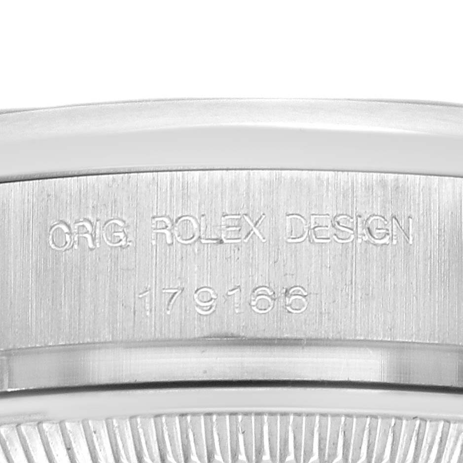 The image shows the side profile of a Rolex President 179166 Women
s Platinum Blue Dial watch, focusing on the engraved serial number and design details.