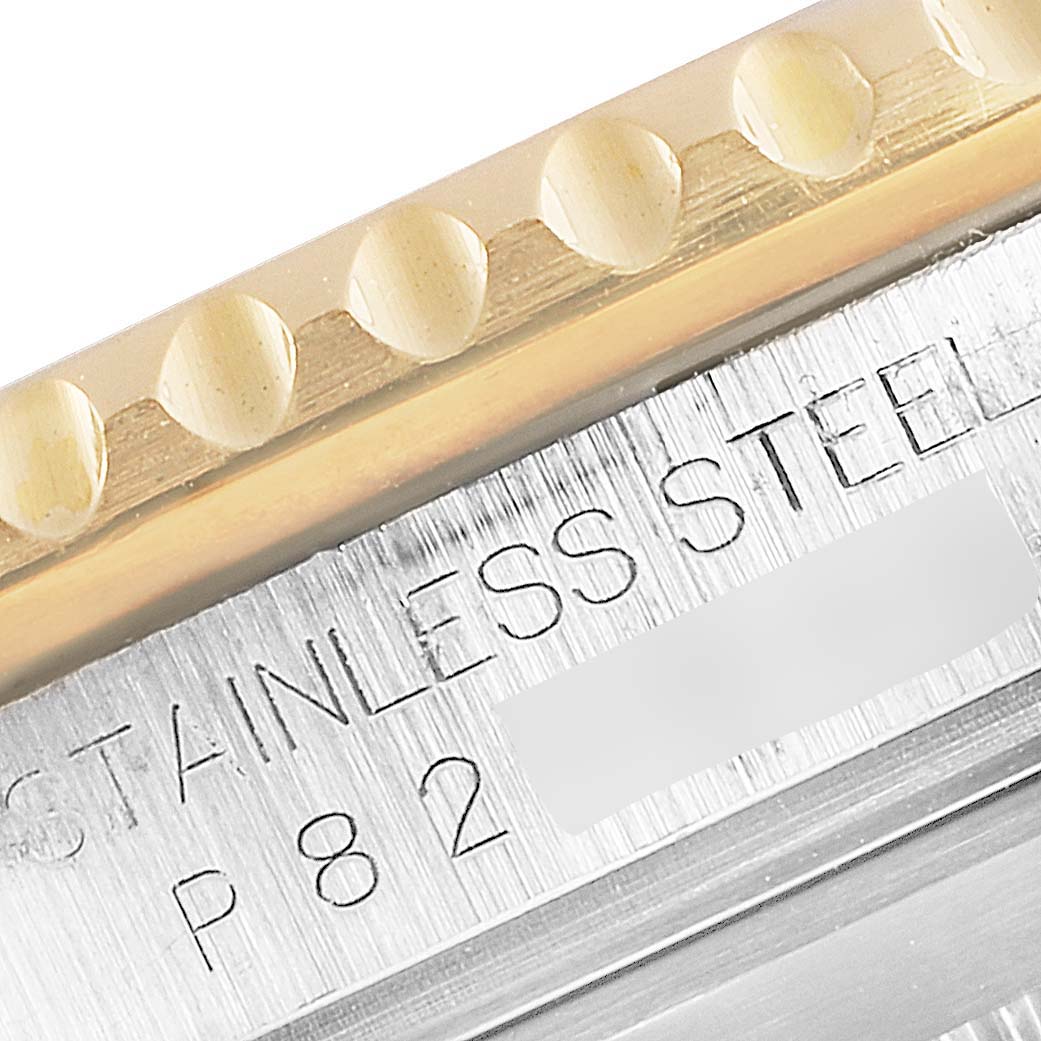 Close-up of the Rolex Submariner 16613 Men's Steel and Gold (two tone) Blue Dial 16613 Men's Steel and Gold (two tone) Blue Dial's bezel and part of the case, showing stainless steel markings.