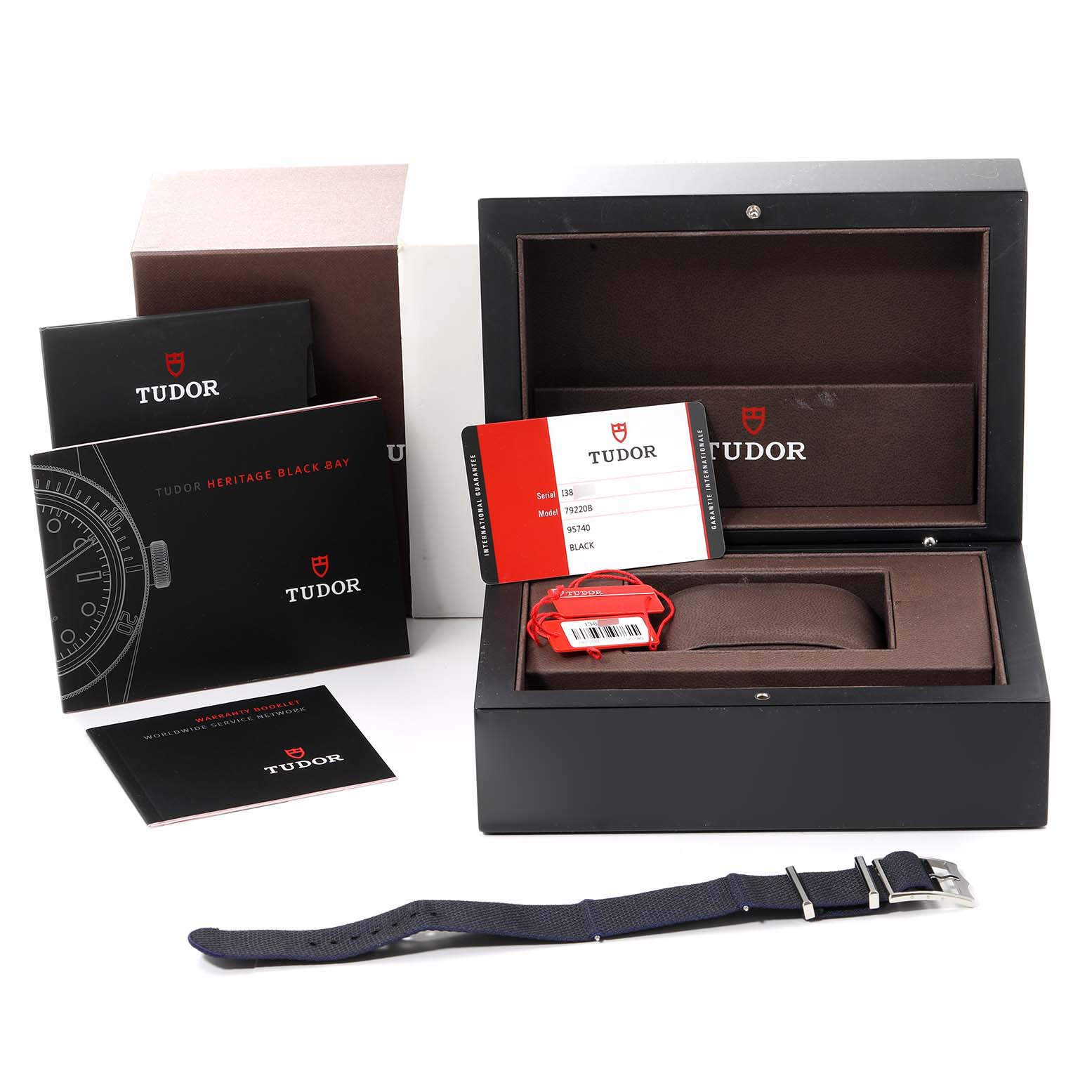 The image shows Tudor Heritage Black Bay 79220 Men's Stainless Steel Black Dial 79220 Men's Stainless Steel Black Dial watch box, manuals, warranty card, and an extra strap from a top-down angle.