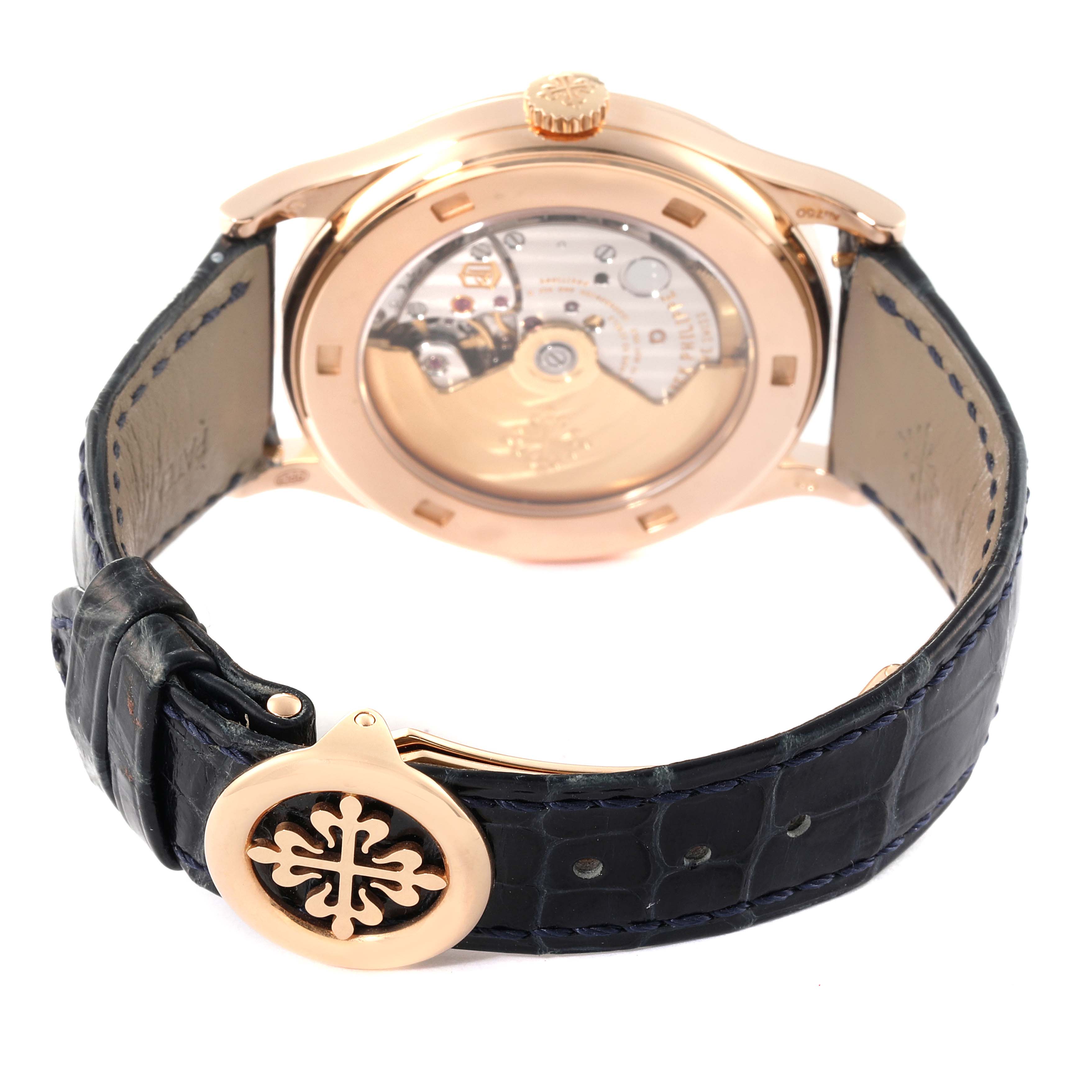 This image displays the back and mechanism of a Patek Philippe Calatrava 5296R Men's Rose Gold Silver Dial 5296R Men's Rose Gold Silver Dial watch, along with its leather strap and buckle.