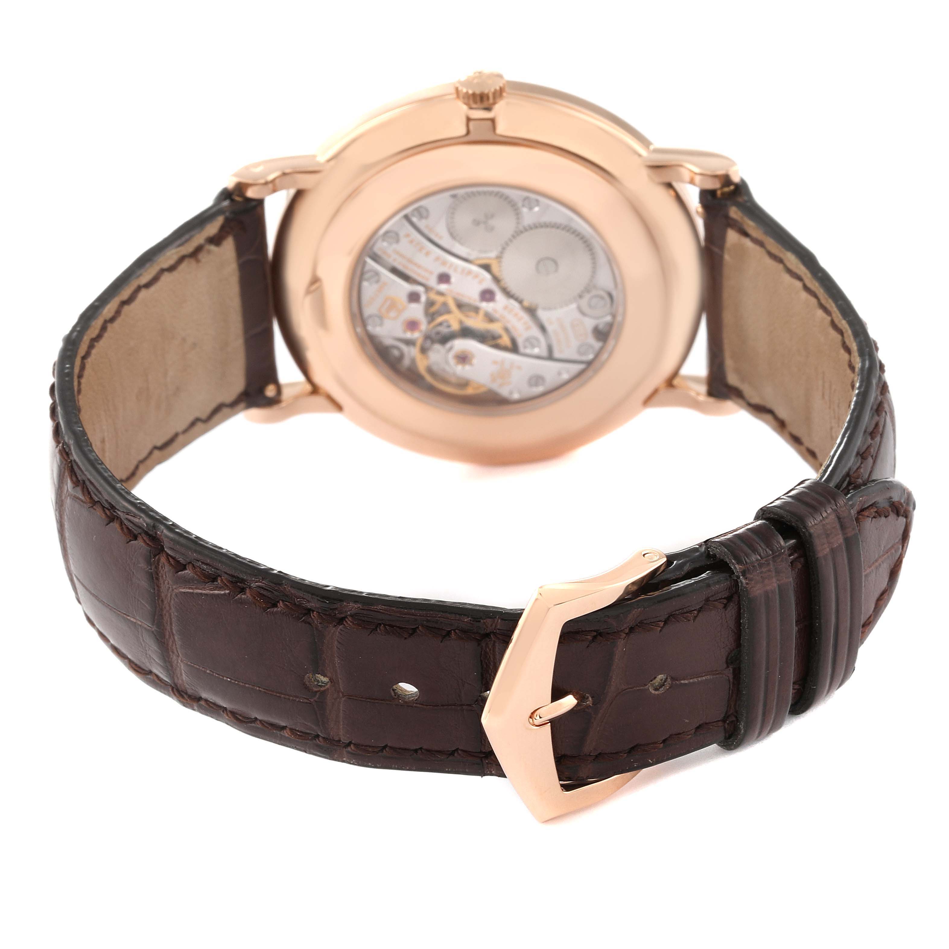The image shows the back of a Patek Philippe Calatrava 5116R-001 Men
s Rose Gold White Dial watch, highlighting the movement through a transparent case back and a leather strap.